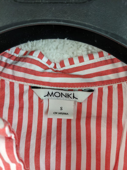 Close-up of Monki label on red striped shirt
