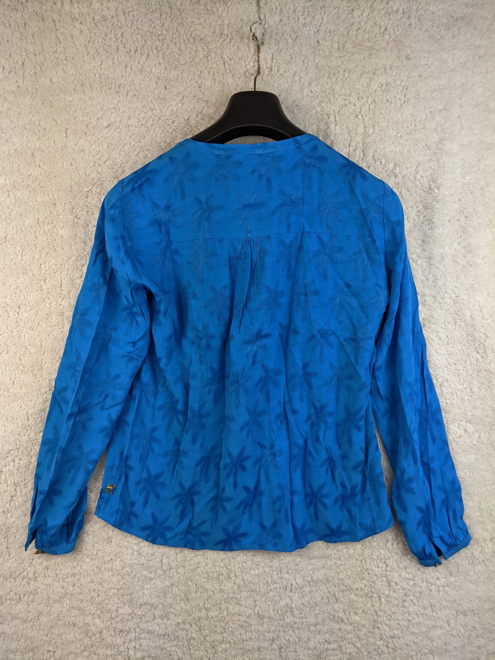 Blue floral blouse on a hanger - back view
