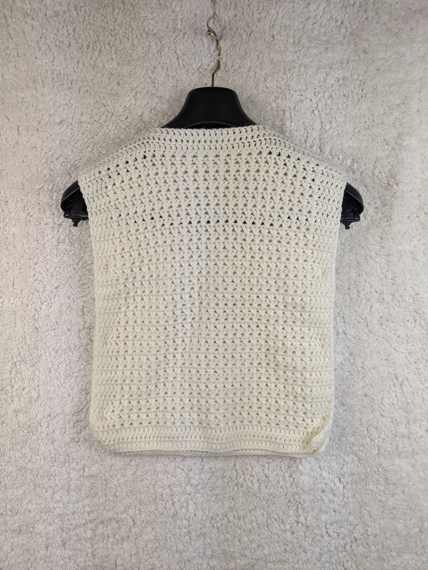 White crochet vest with buttons, back view on hanger