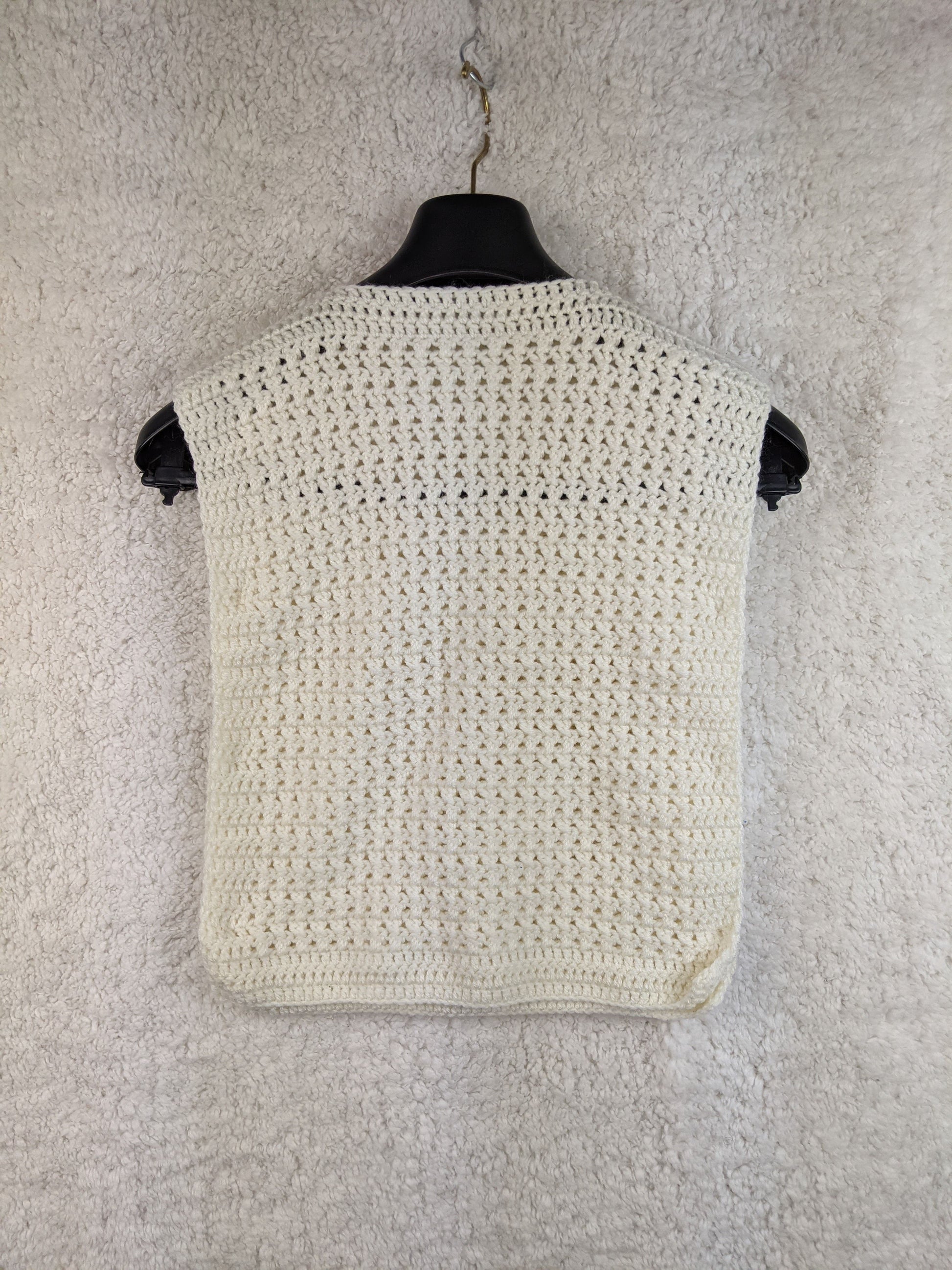 White crochet vest with buttons, back view on hanger