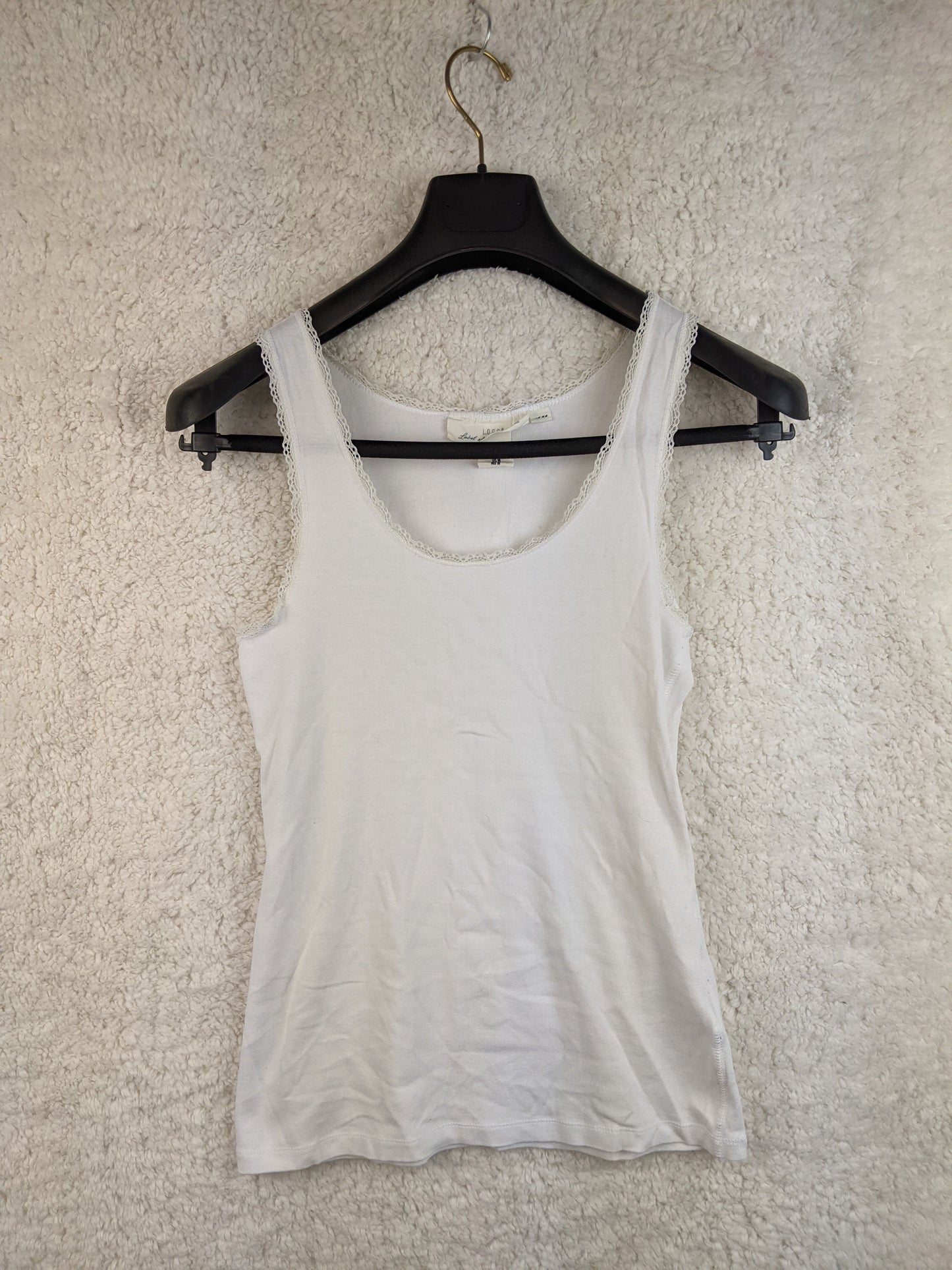 Front view of white lace trim tank top on hanger