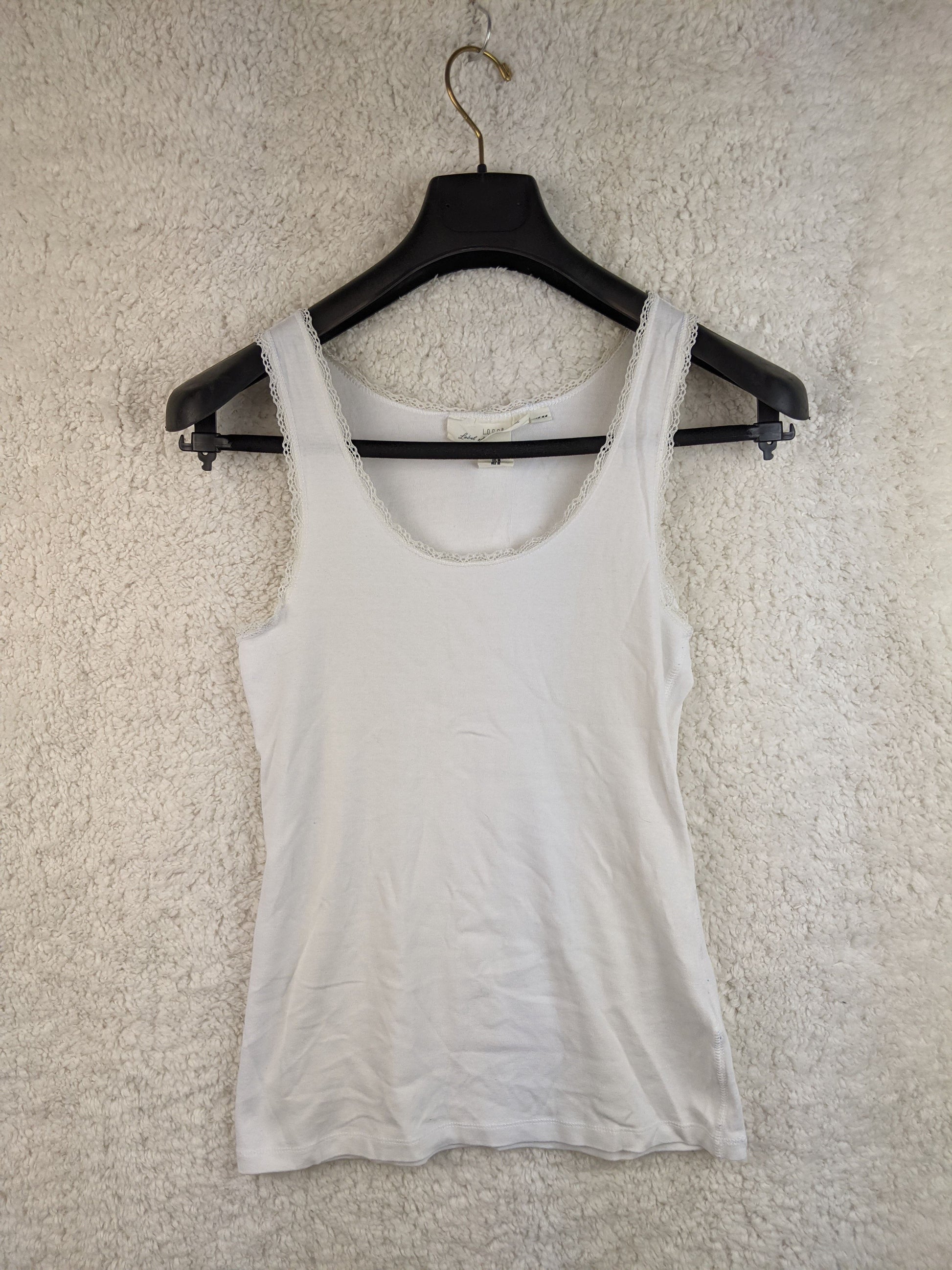 Front view of white lace trim tank top on hanger