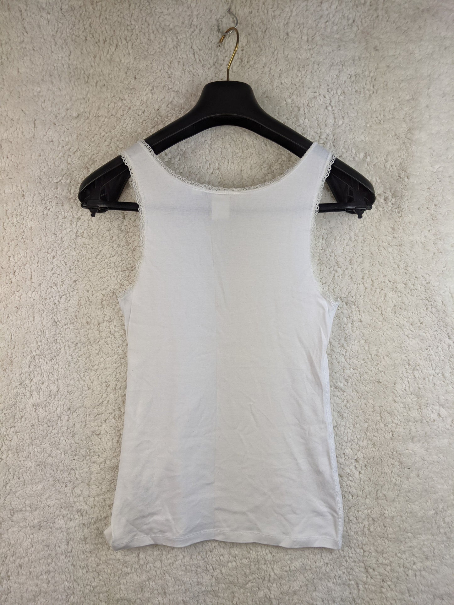 Back view of white lace trim tank top on hanger