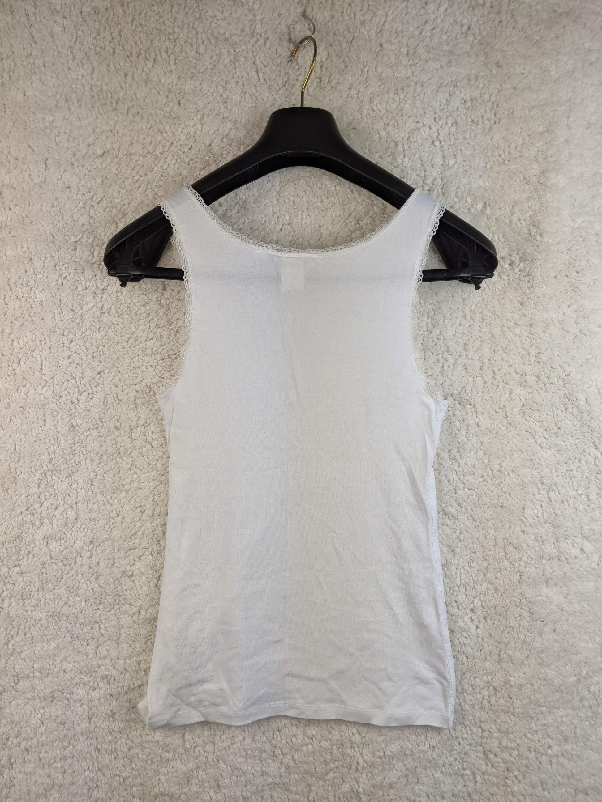 Back view of white lace trim tank top on hanger