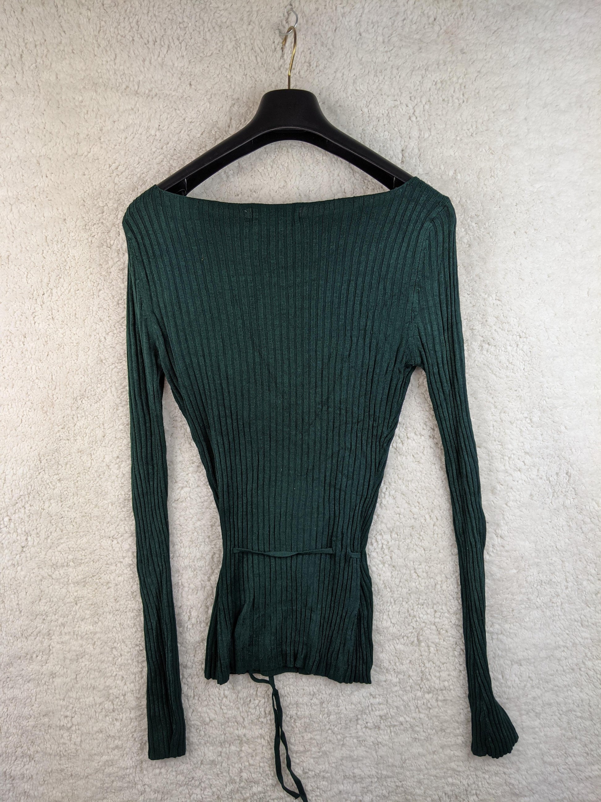 Back view of green ribbed knit top on hanger