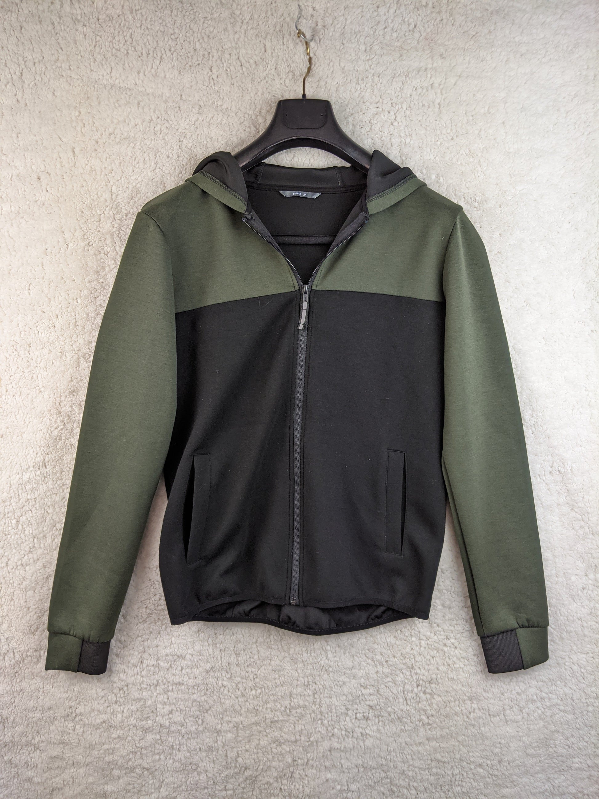 Front view of a green and black hoodie on a hanger
