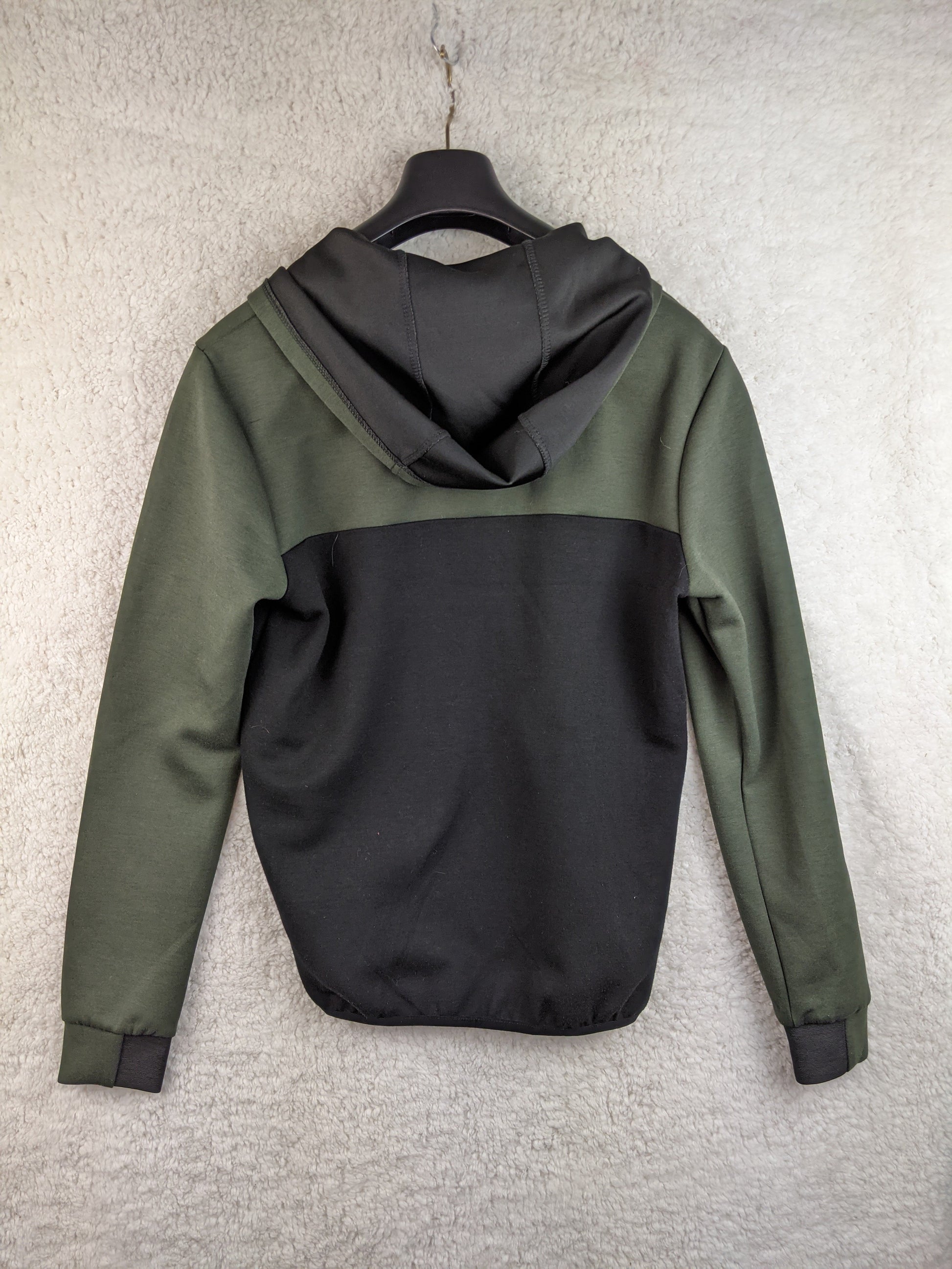 Back view of a green and black hoodie on a hanger