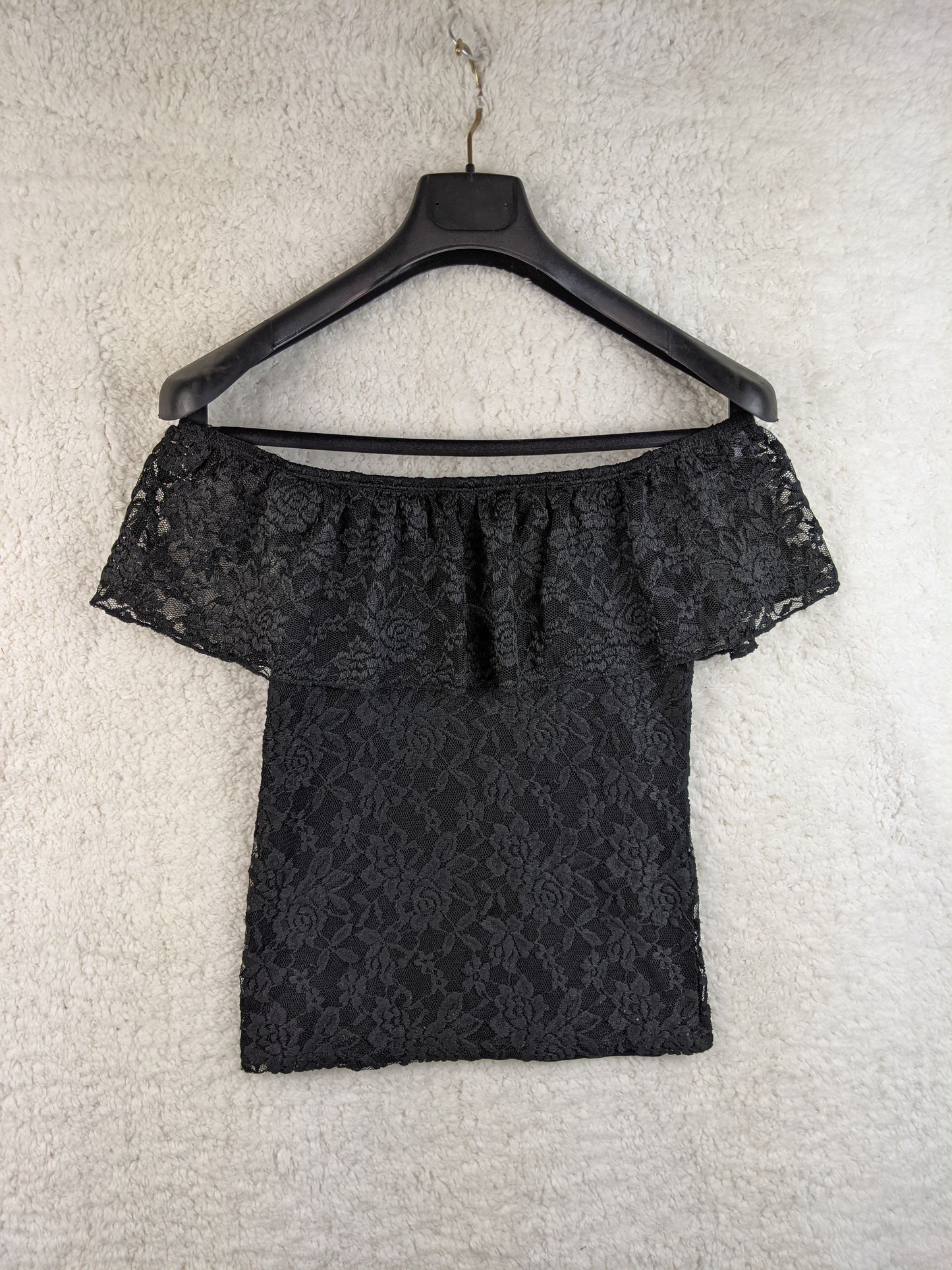 Black lace off-shoulder top on hanger front view
