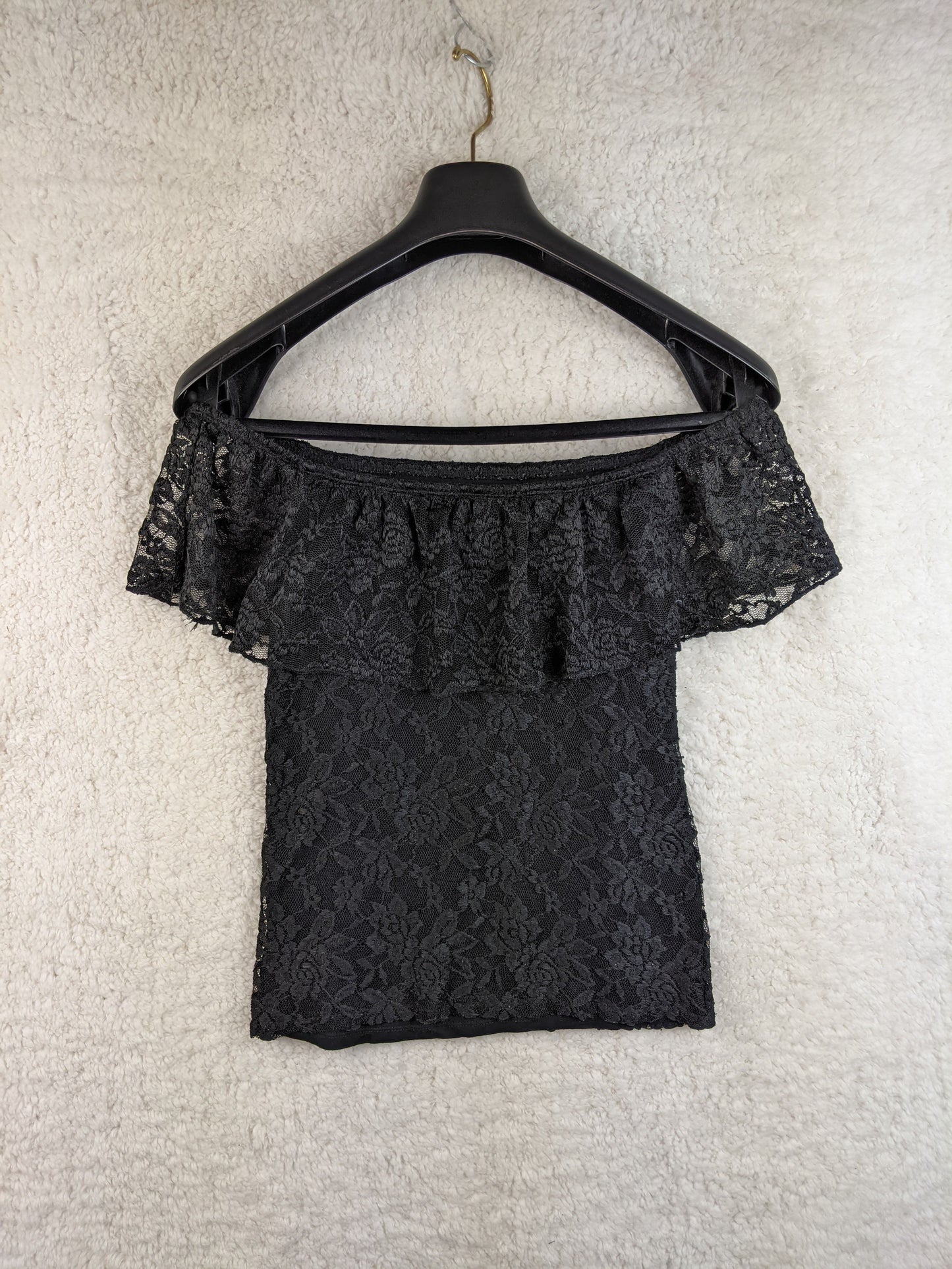 Black lace off-shoulder top on hanger back view