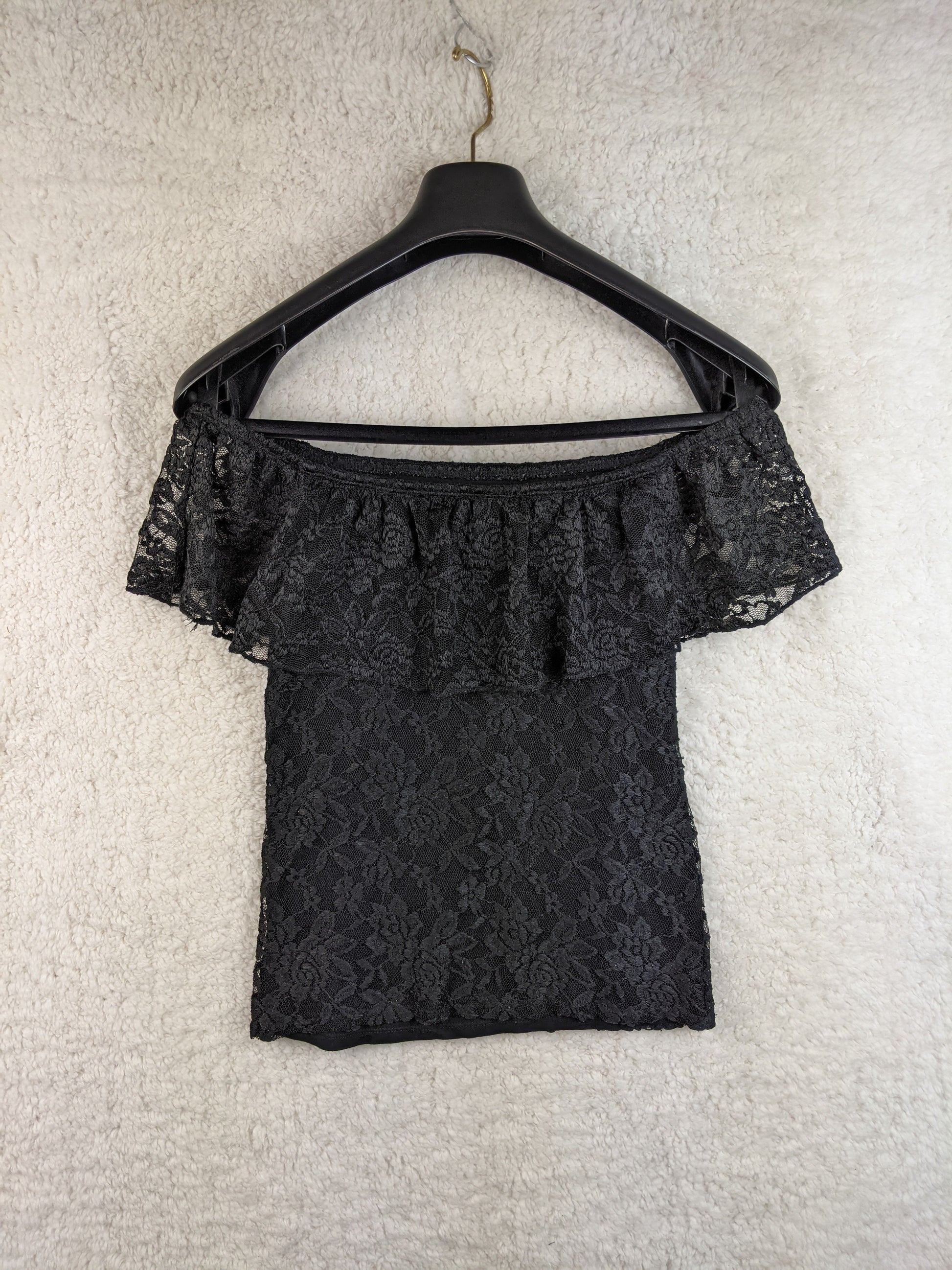 Black lace off-shoulder top on hanger back view