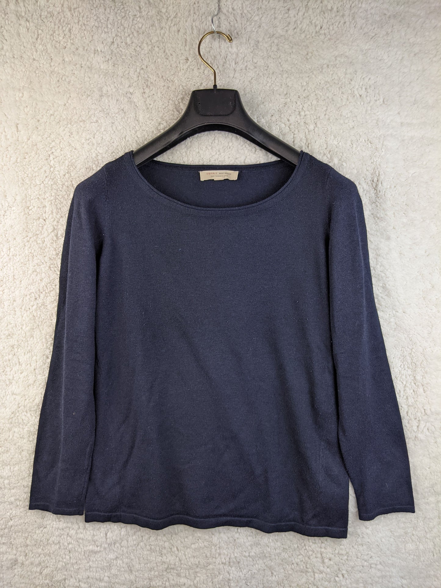 Front view of a navy blue long sleeve top on a hanger