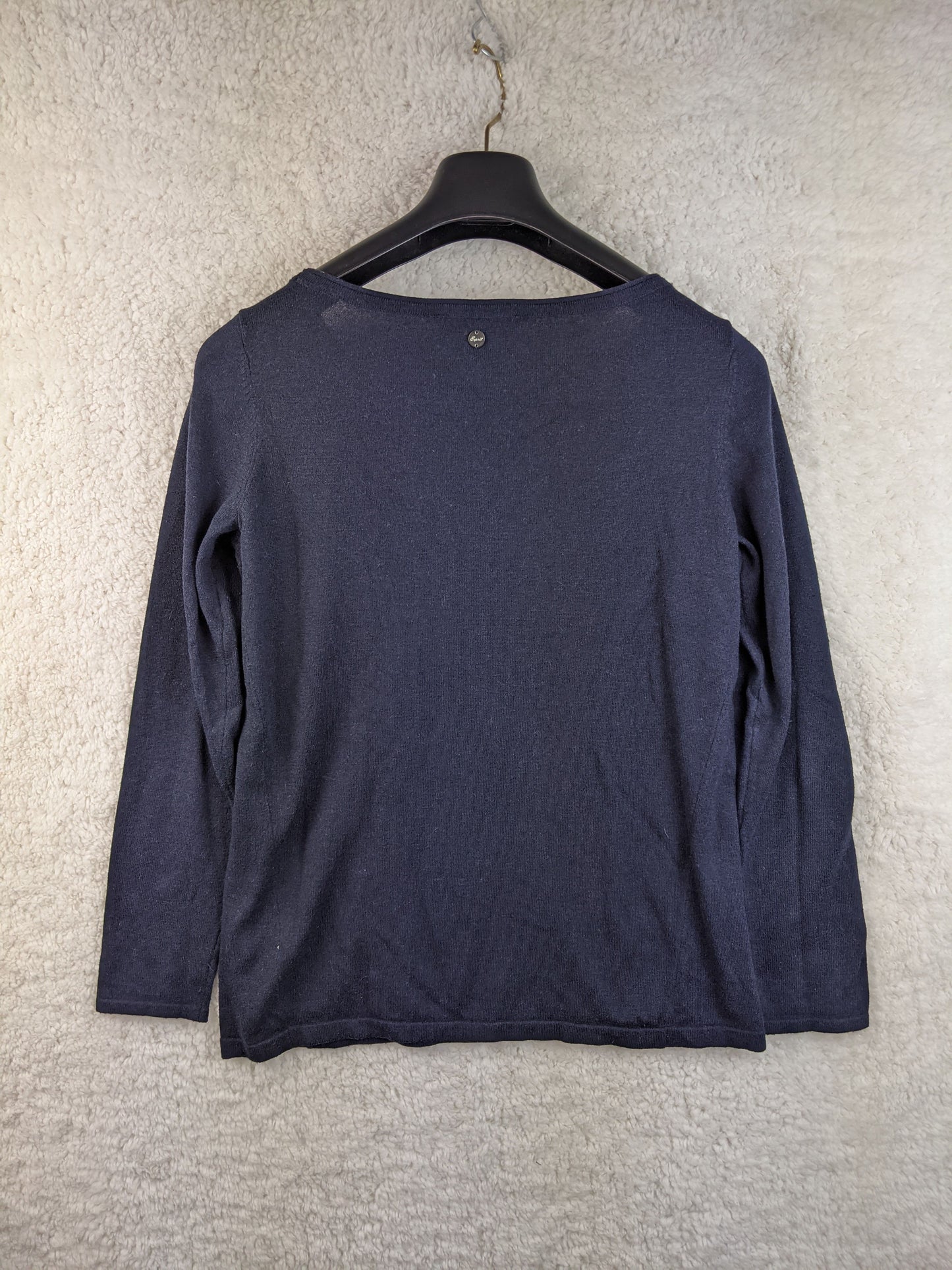 Back view of a navy blue long sleeve top on a hanger