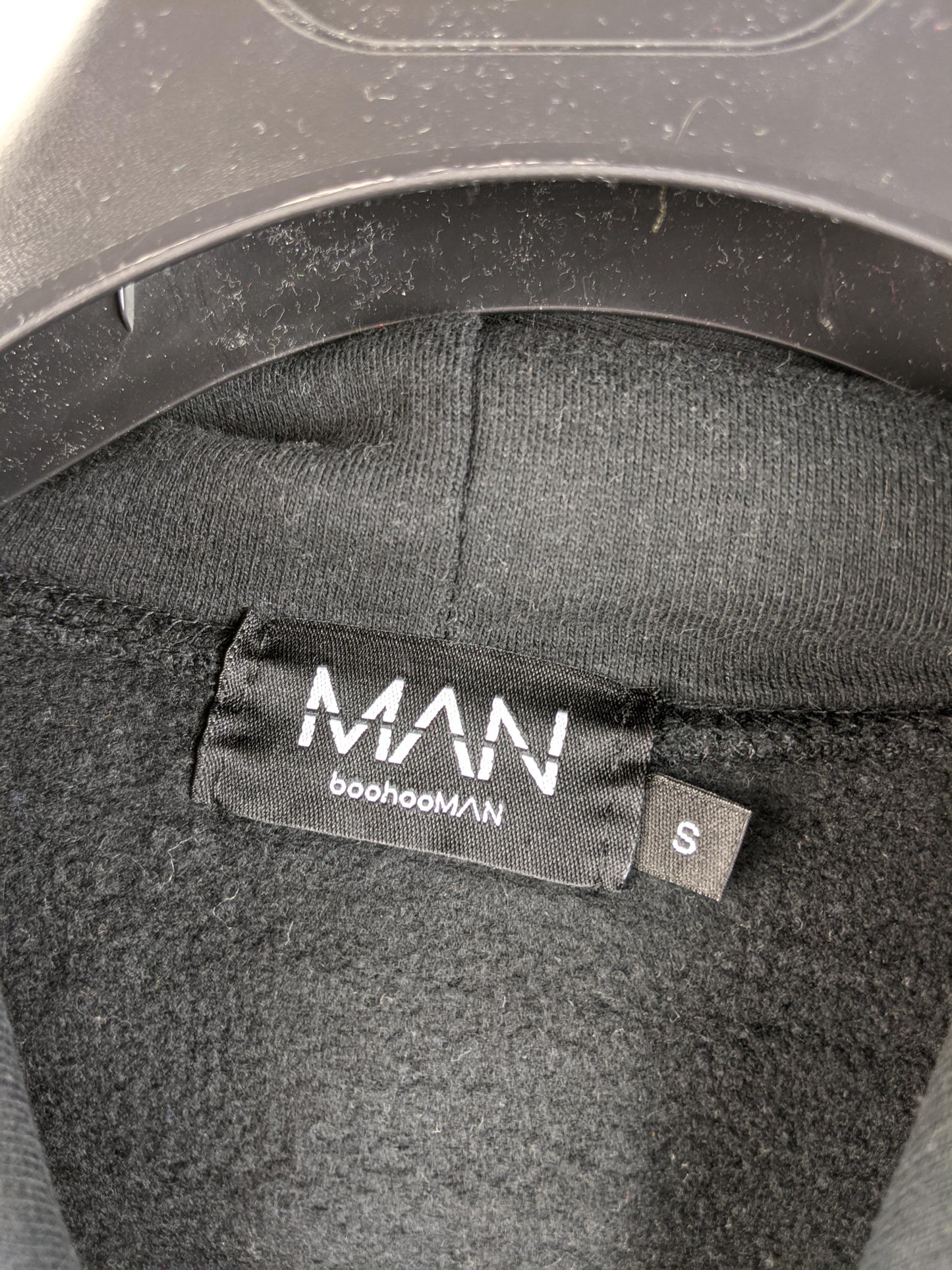 Close-up of boohooMAN label and size tag