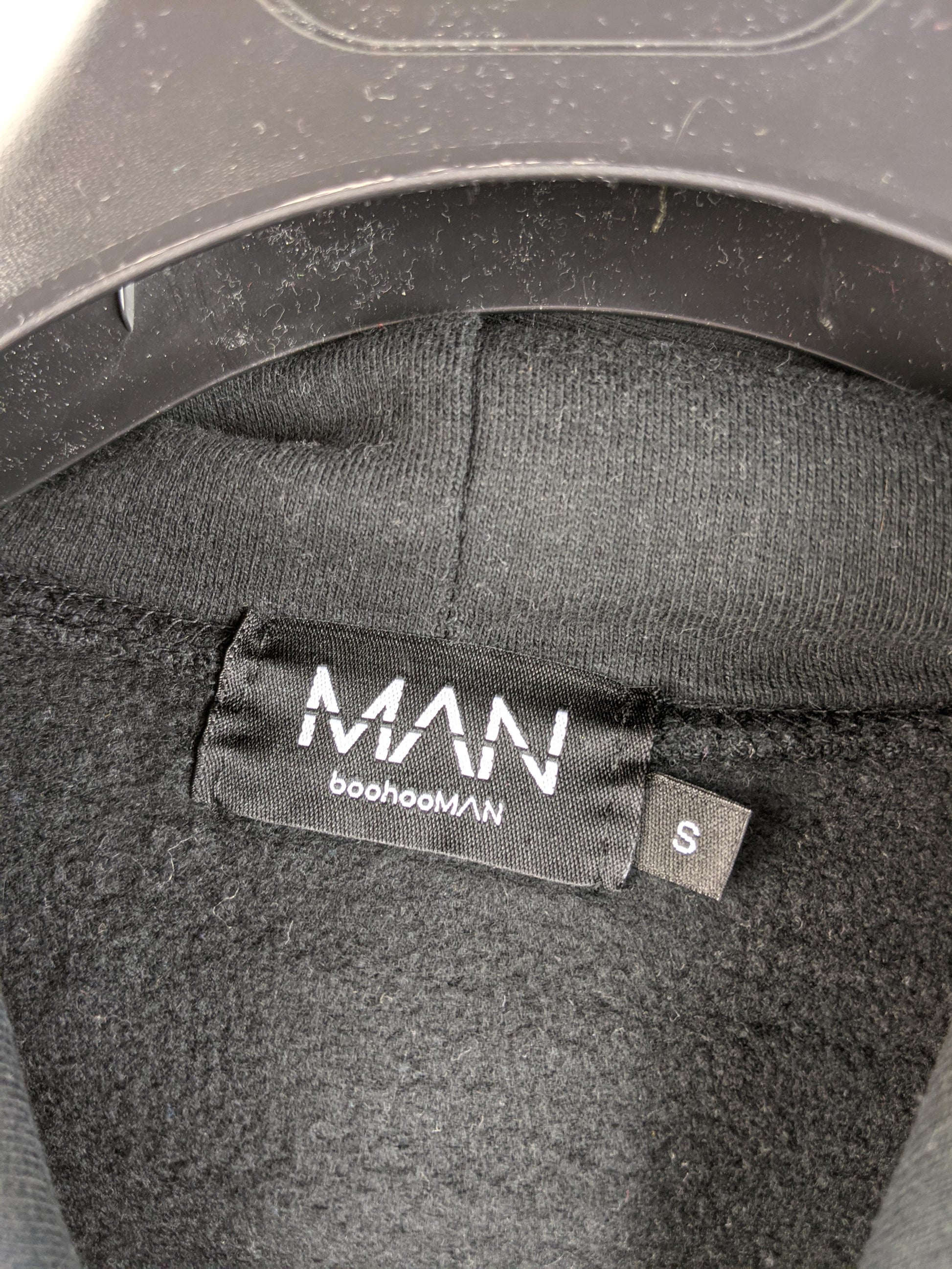 Close-up of boohooMAN label and size tag