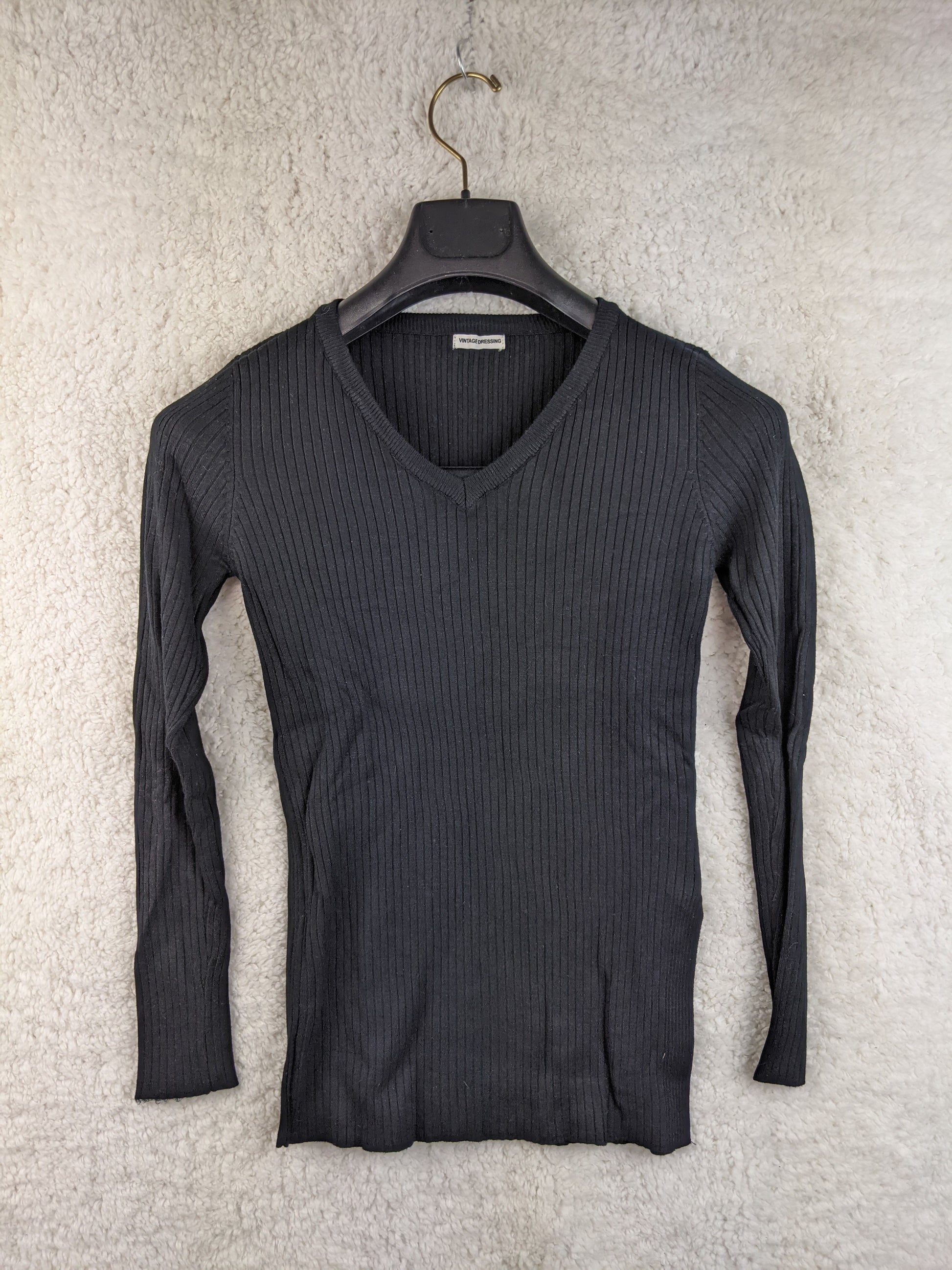 Black ribbed knit sweater on hanger