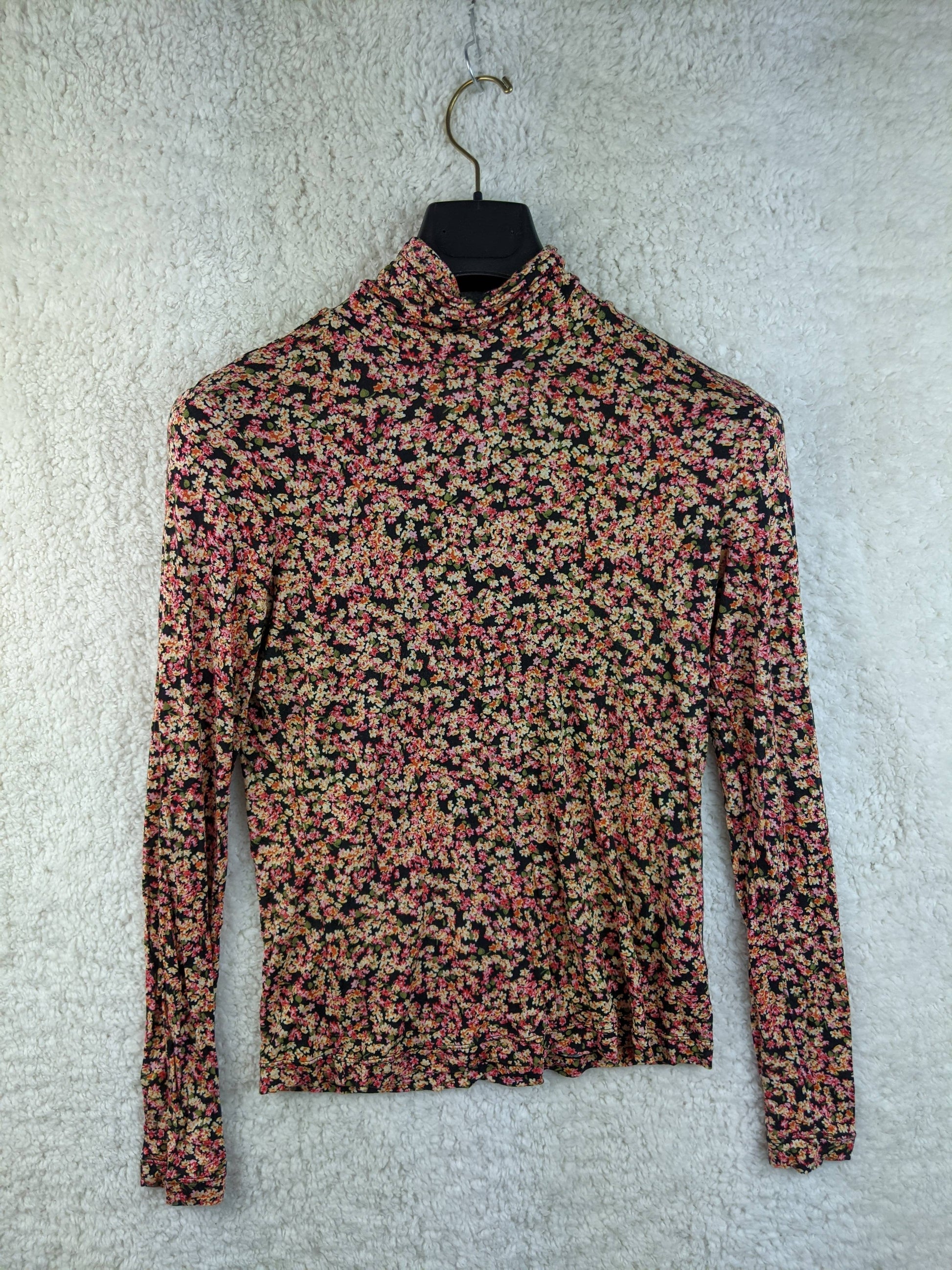 Floral print long sleeve top hanging on a hanger