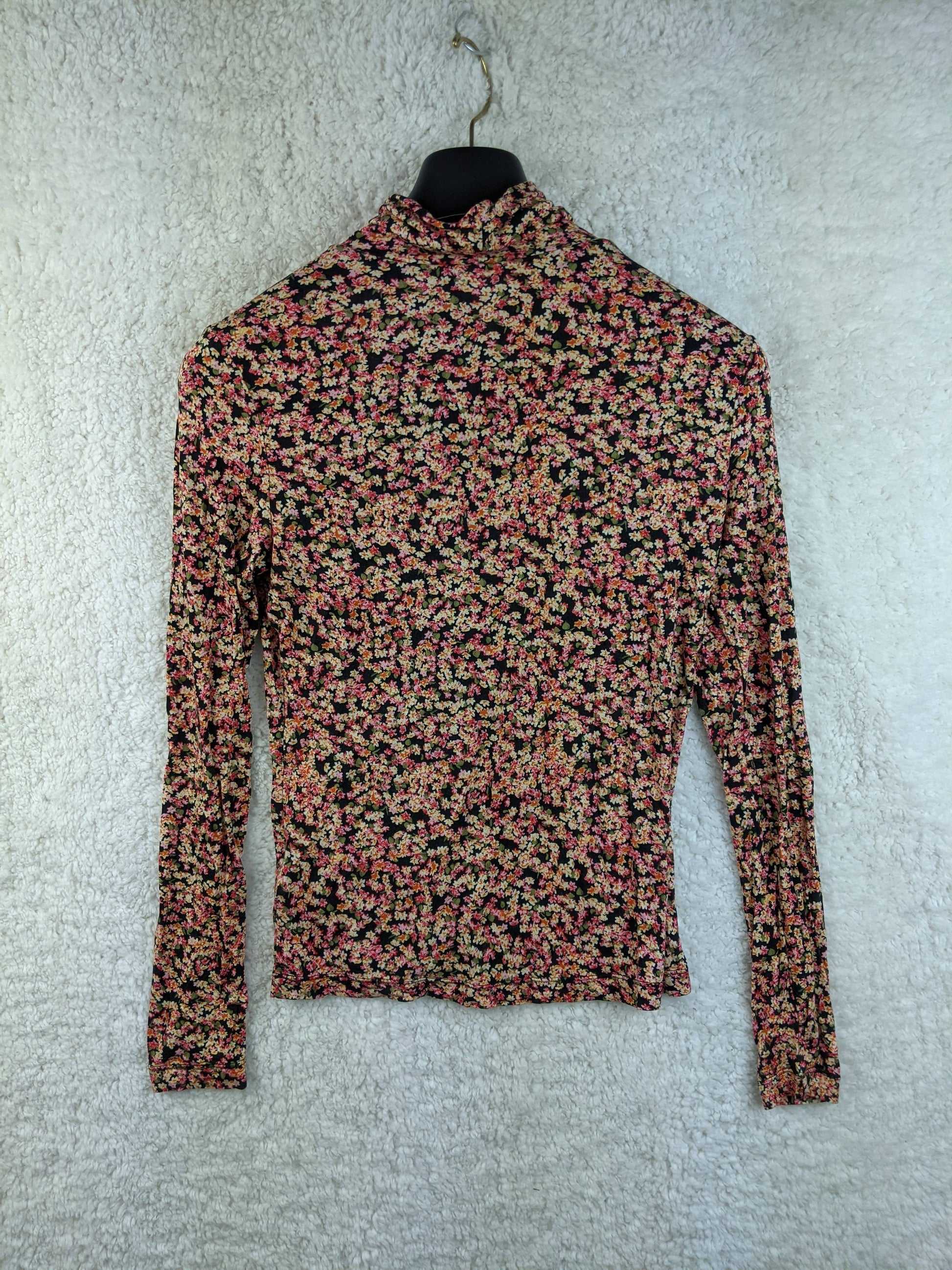 Back view of floral print long sleeve top on a hanger