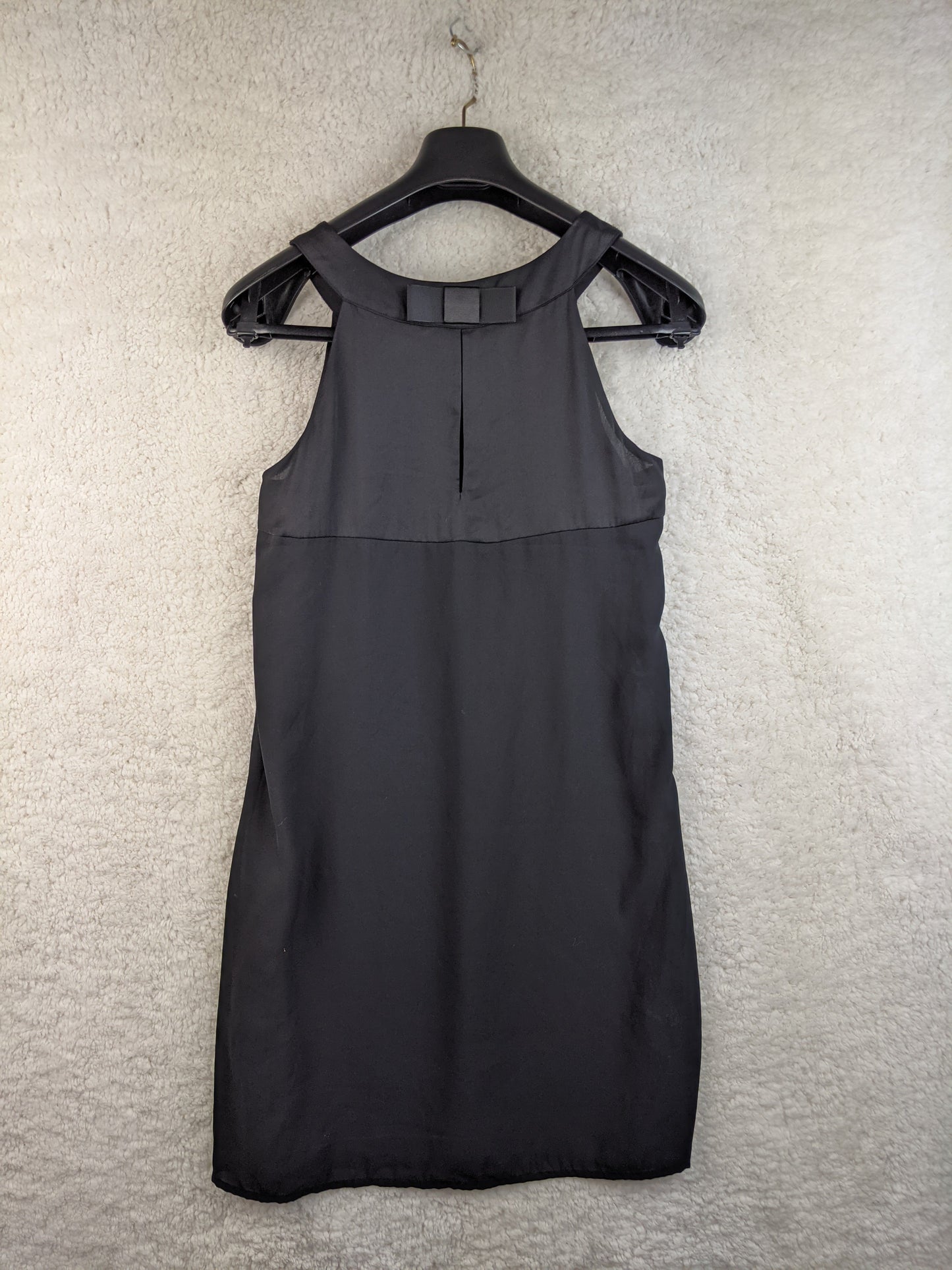 Back view of black sleeveless dress on a hanger