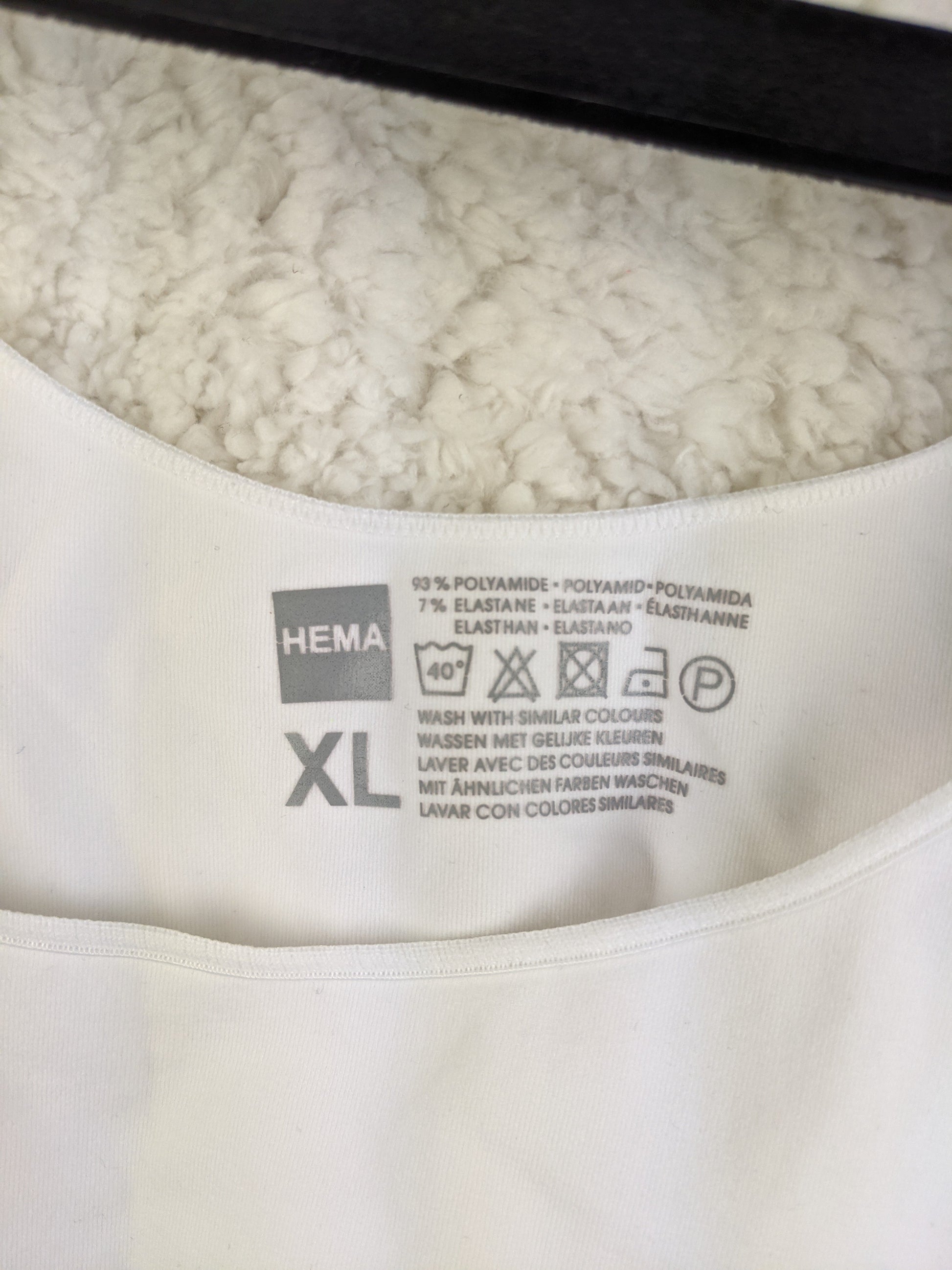 Close up of Hema label showing size XL and material details