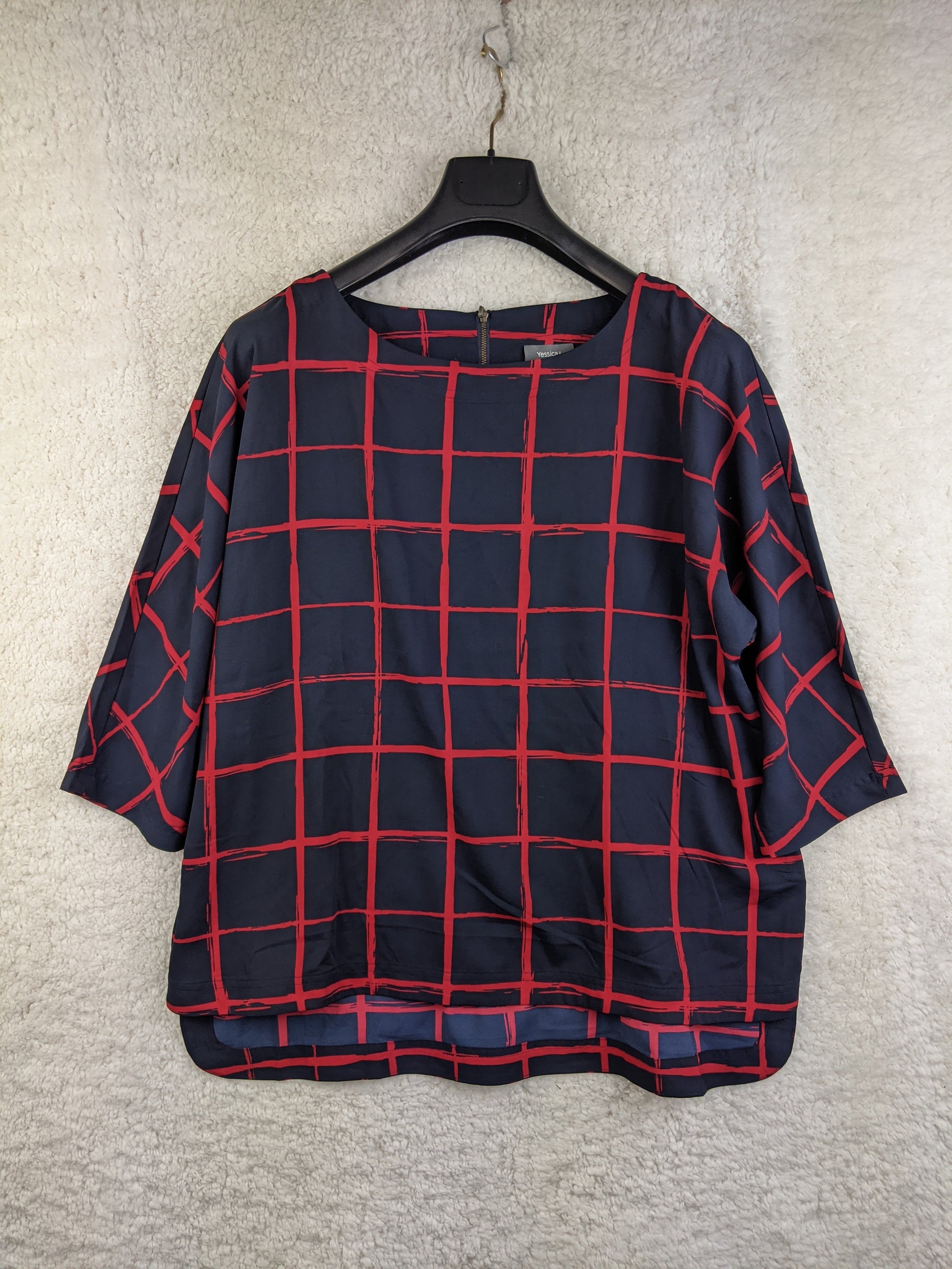 Navy and red checkered blouse on hanger - front view