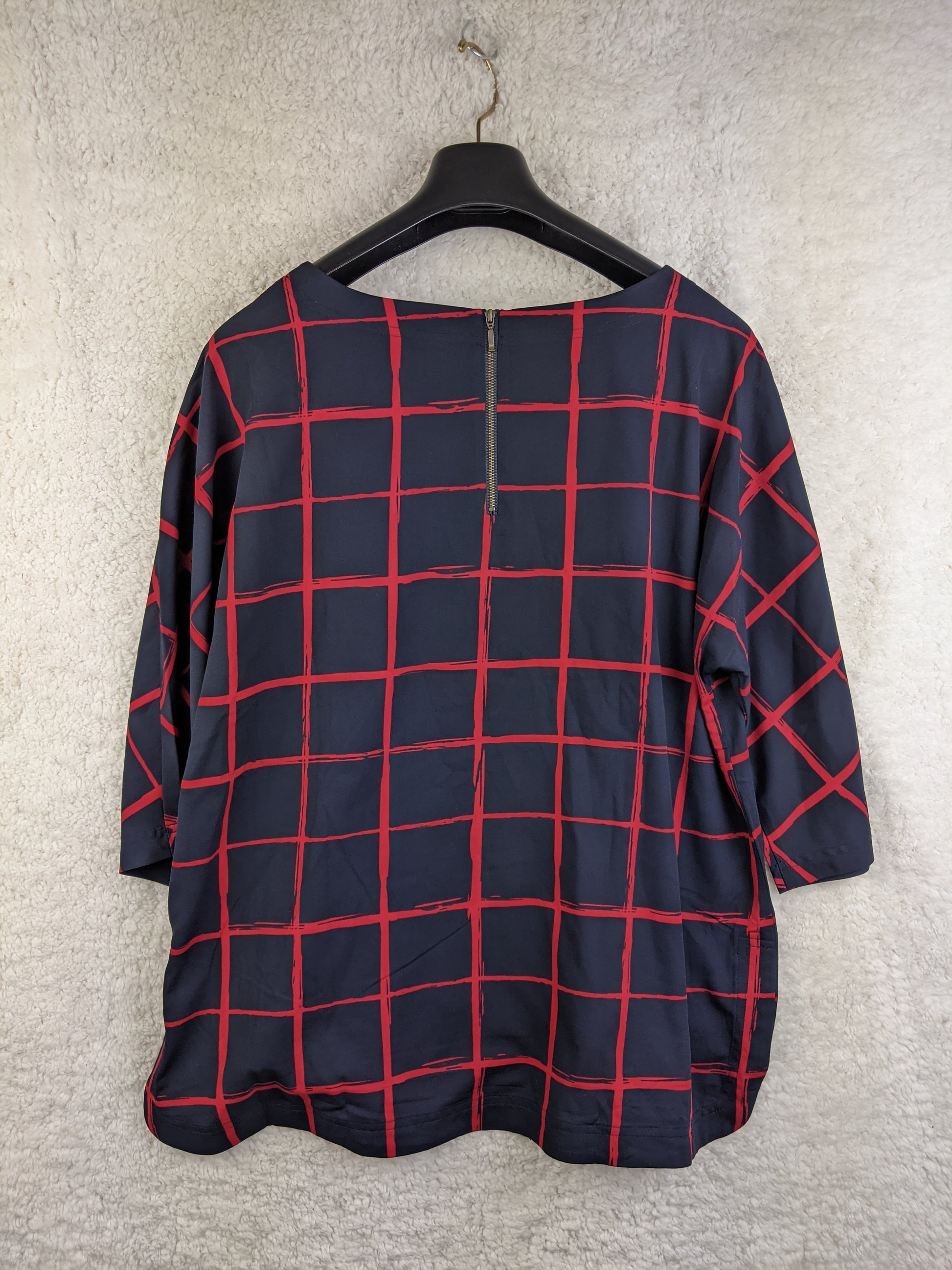 Navy and red checkered blouse on hanger - back view