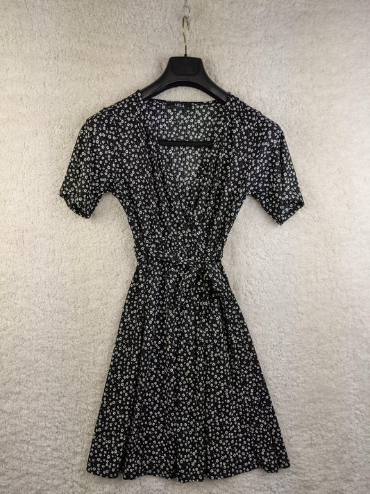 Front view of Lela black floral wrap dress