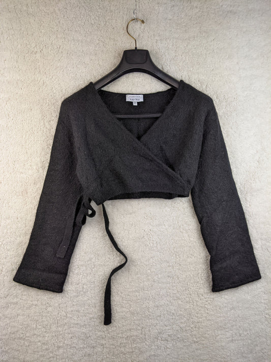 Front view of black wrap cropped sweater on hanger