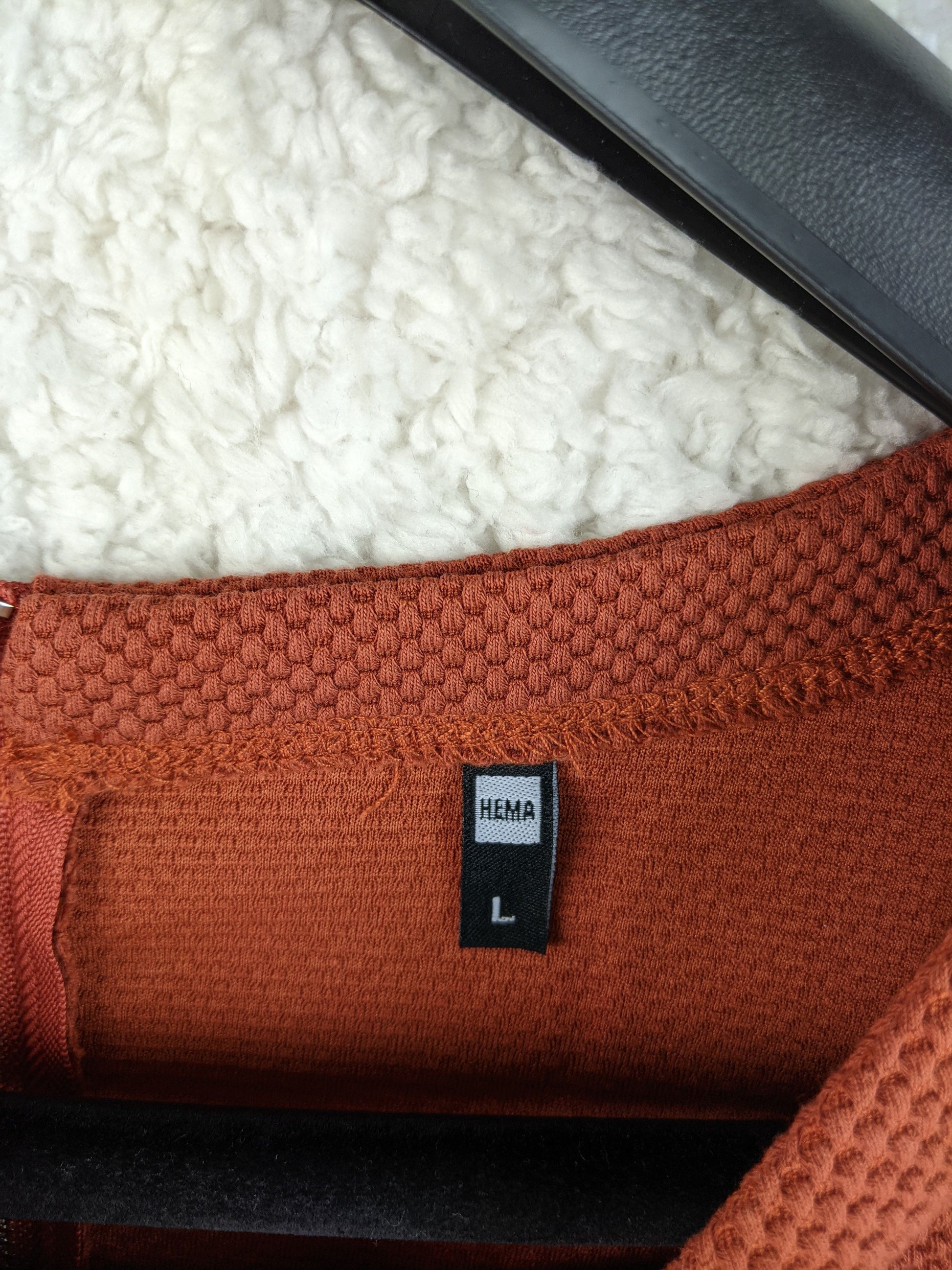 Close-up of Hema label on burnt orange dress