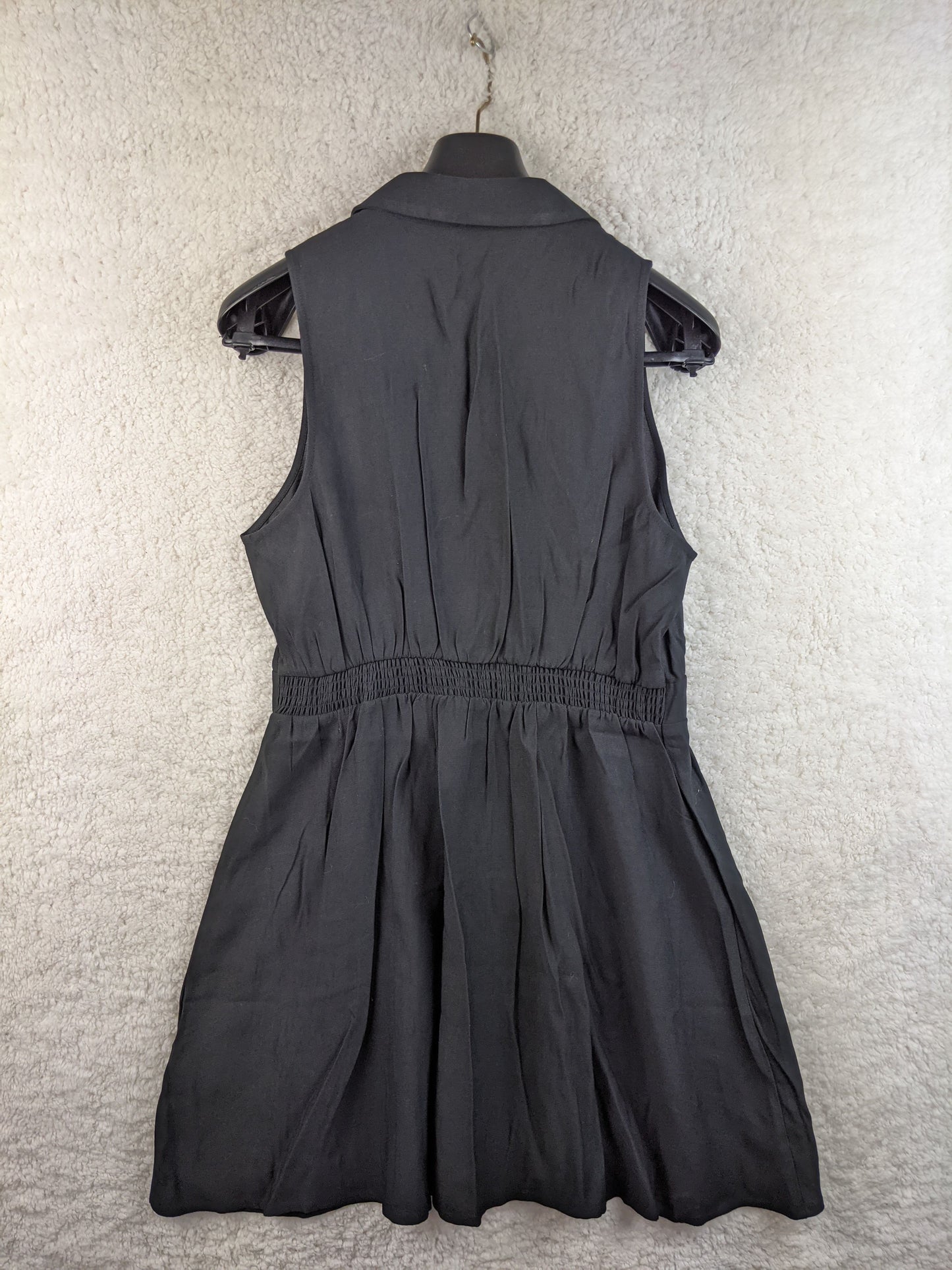 Back view of black sleeveless button-down dress by Cache Cache