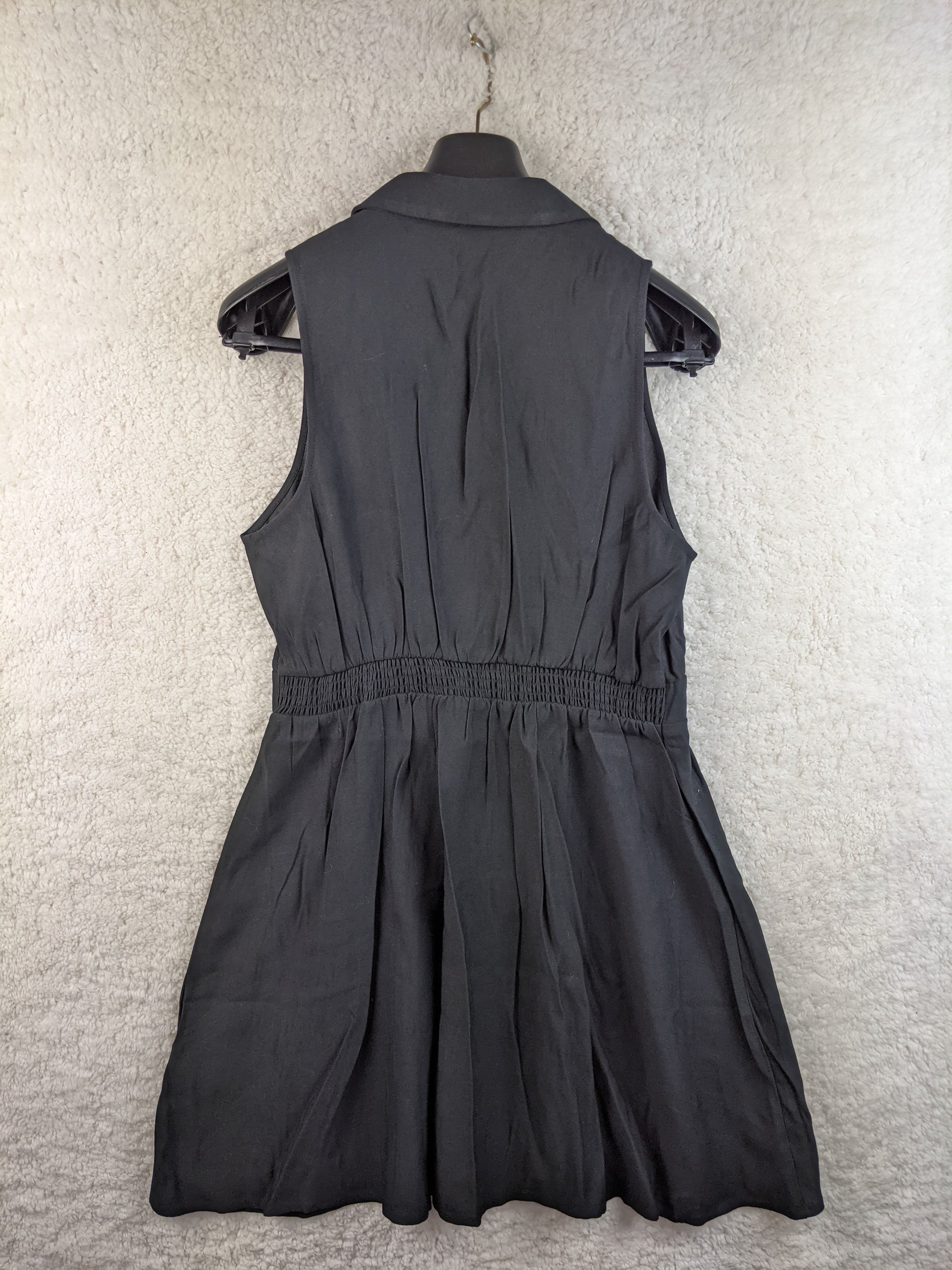 Back view of black sleeveless button-down dress by Cache Cache
