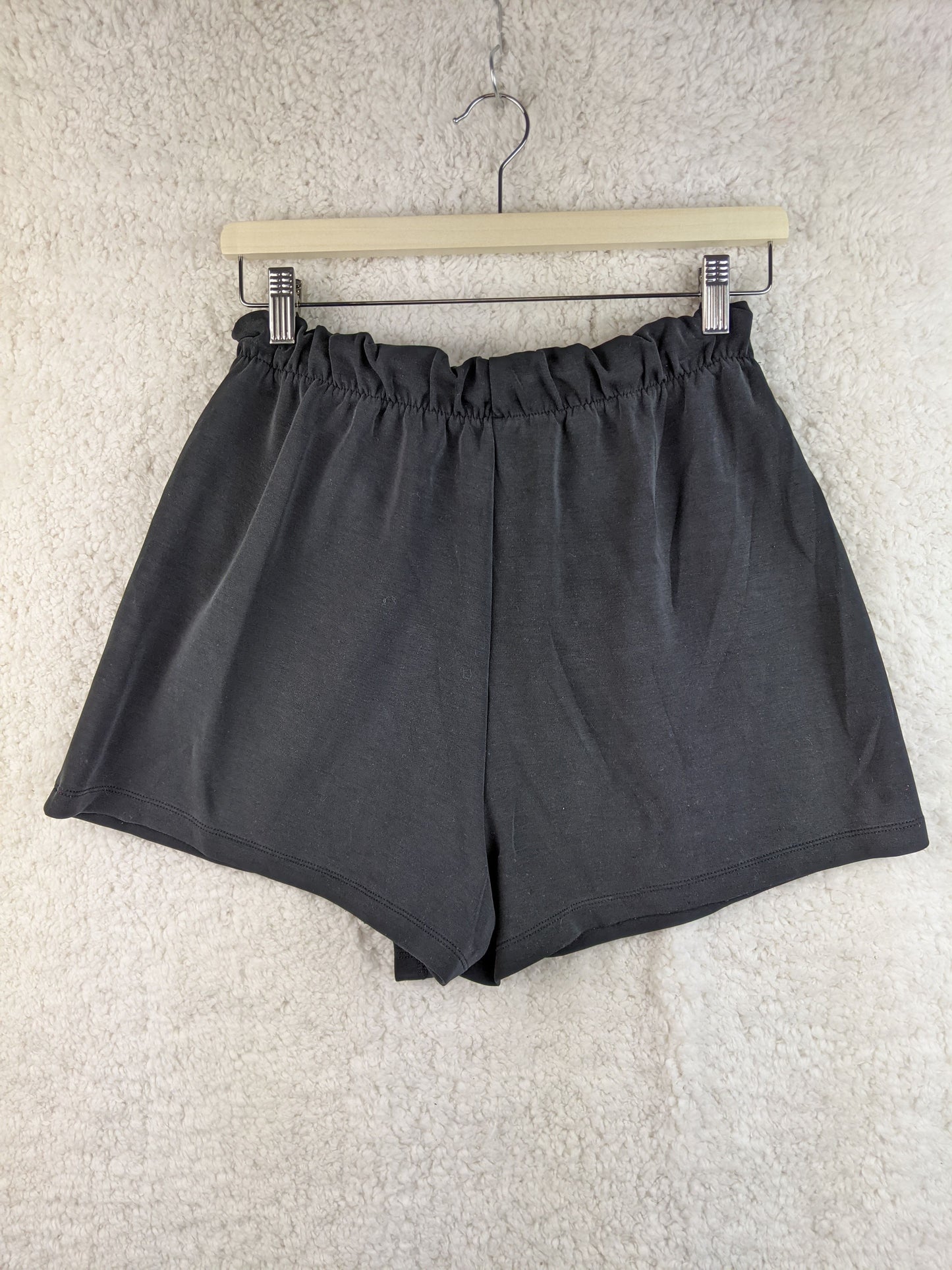 Back view of gray wrap-style shorts on hanger