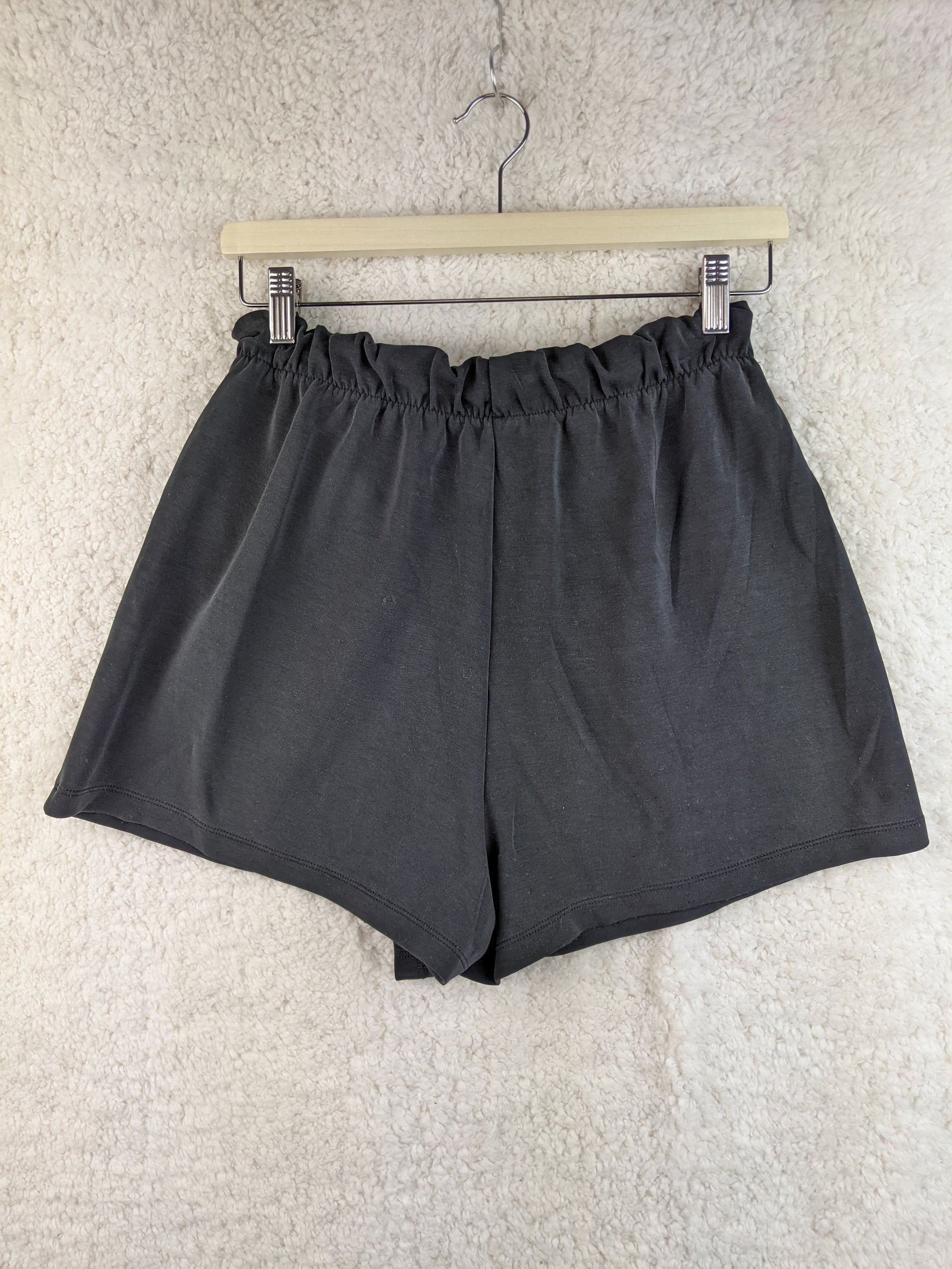 Back view of gray wrap-style shorts on hanger