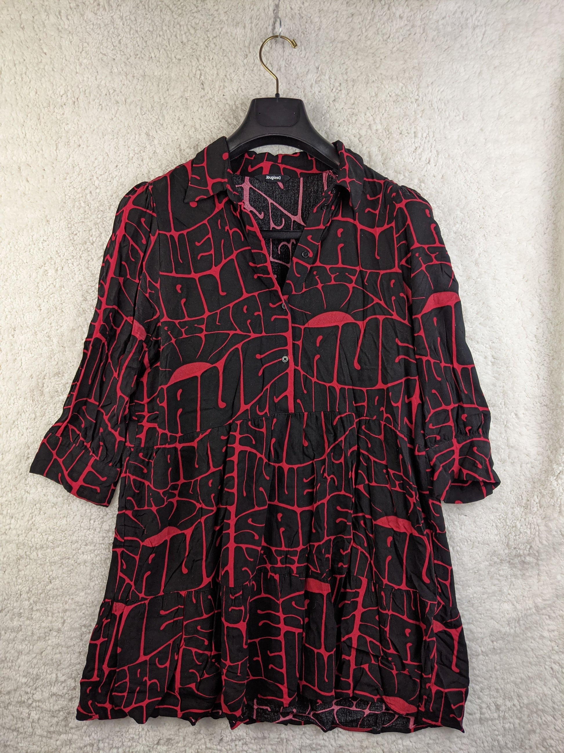 Front view of black and red printed Desigual dress on a hanger