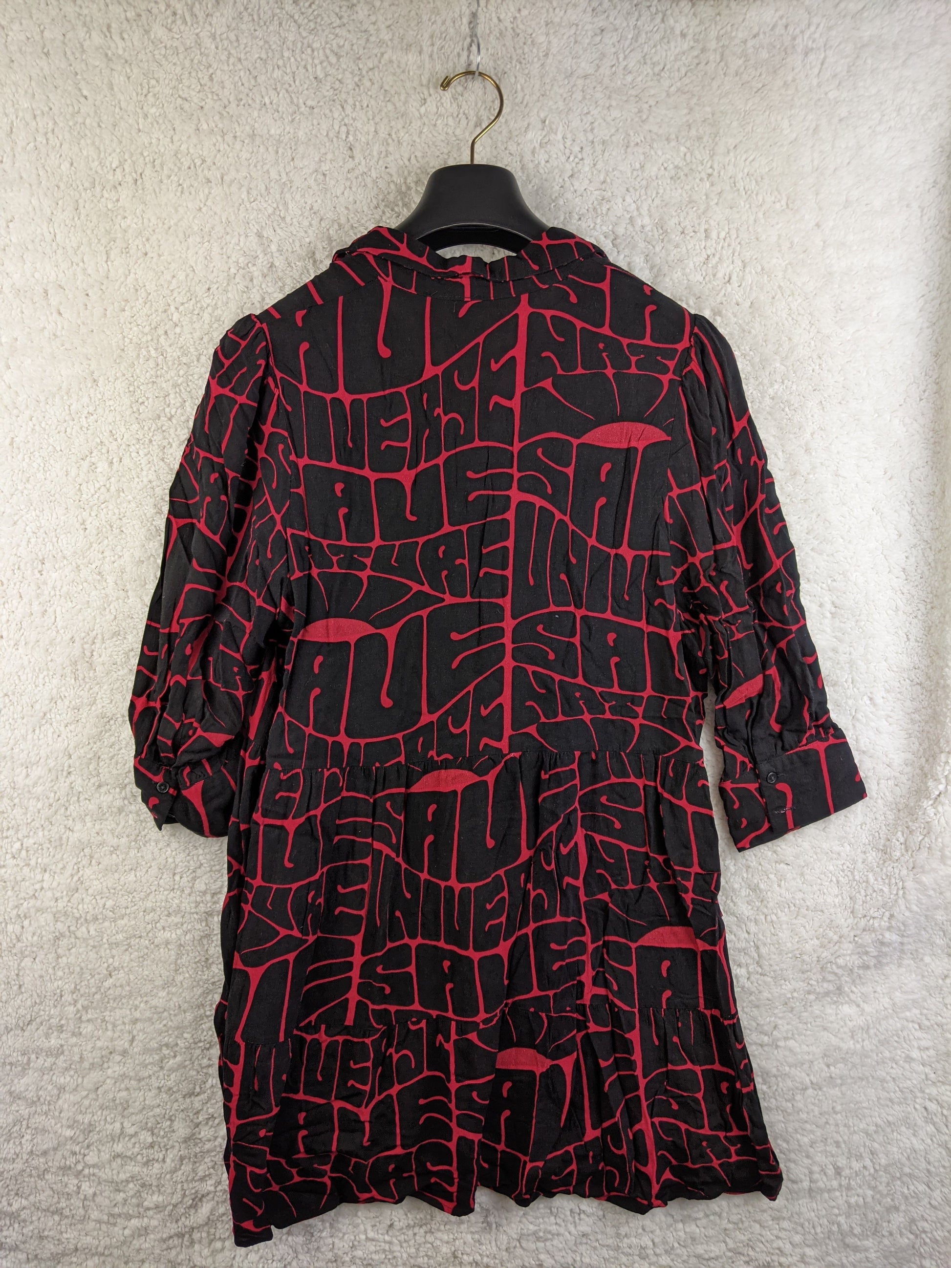 Back view of black and red printed Desigual dress on a hanger
