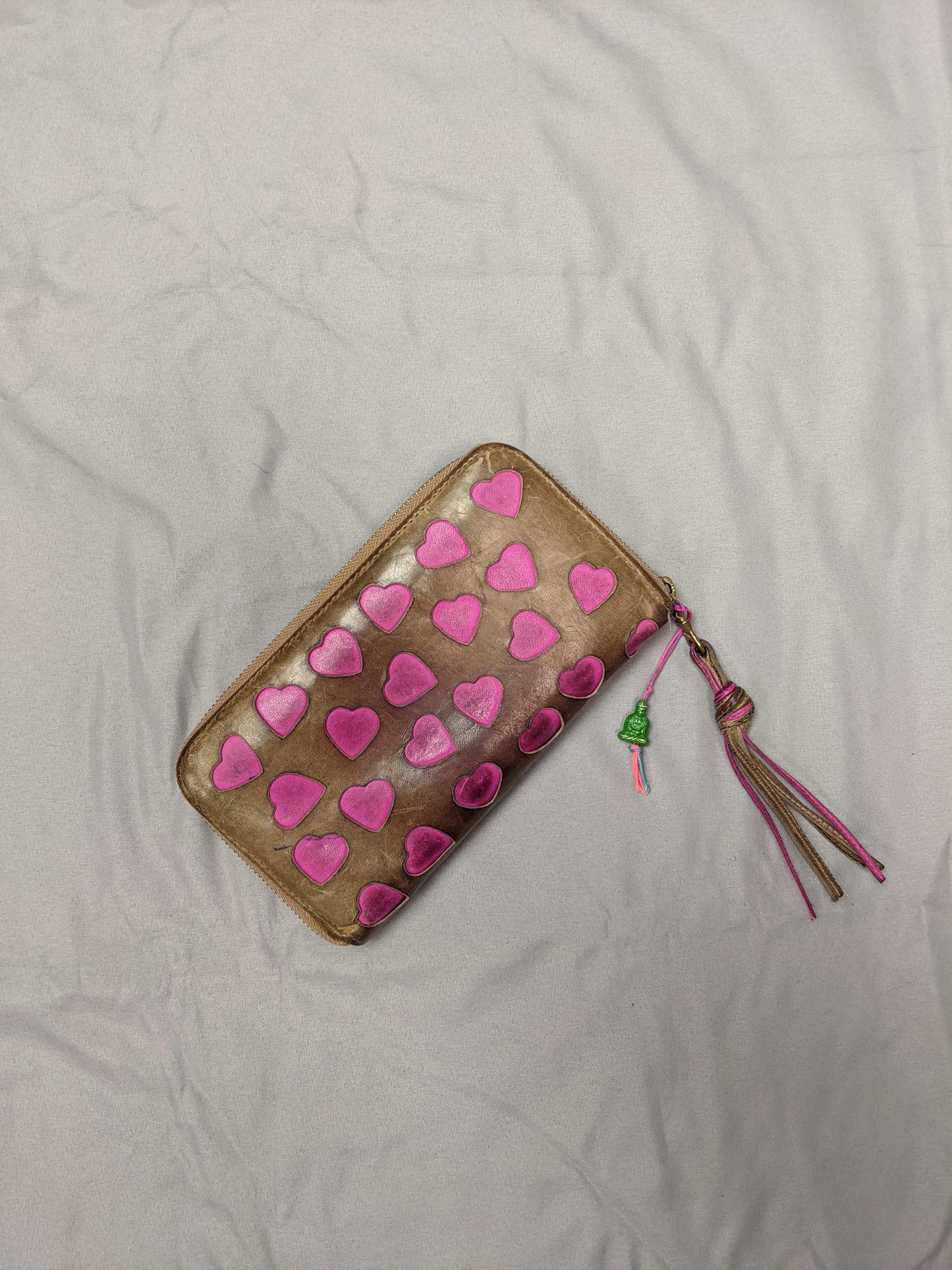 Heart-patterned wallet with tassel on a flat surface