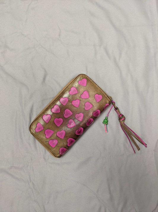 Heart-patterned wallet with tassel on a flat surface