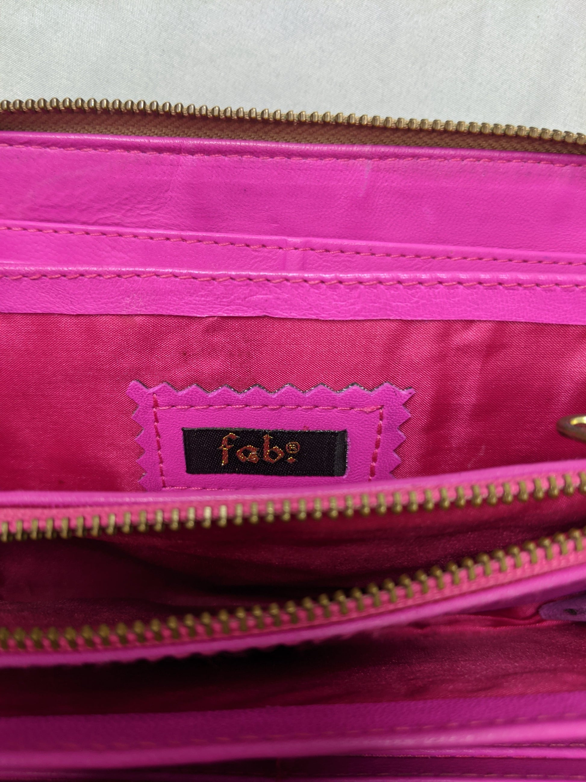 Interior view of wallet showing pink lining and Fab label