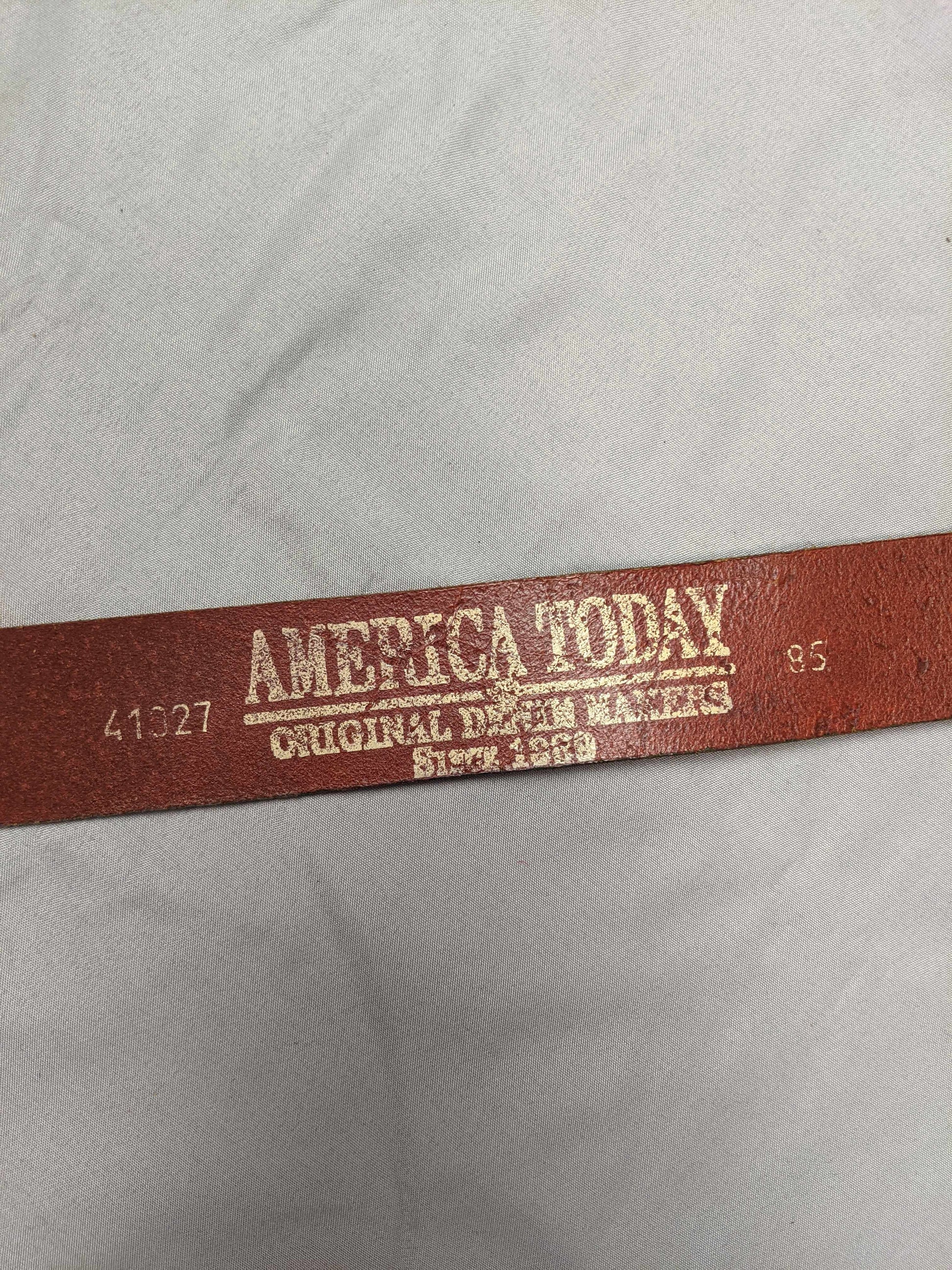 Close-up of America Today logo on brown leather belt