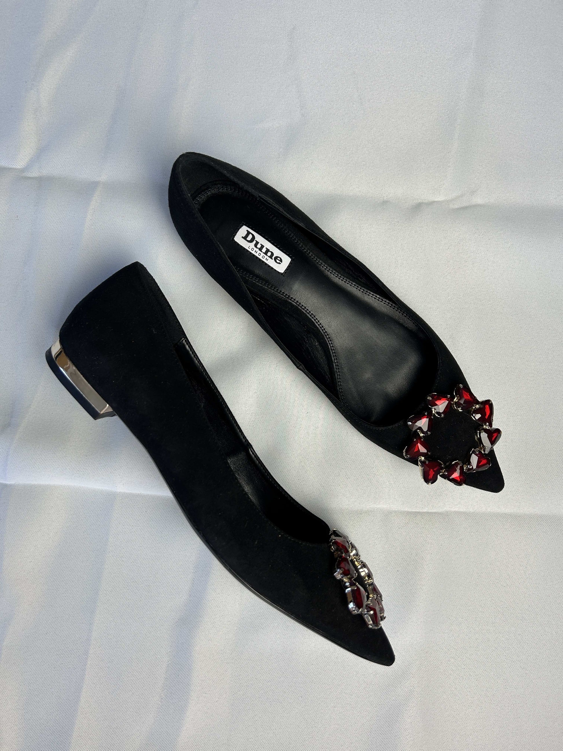 Side view of black ballet flats with embellishments