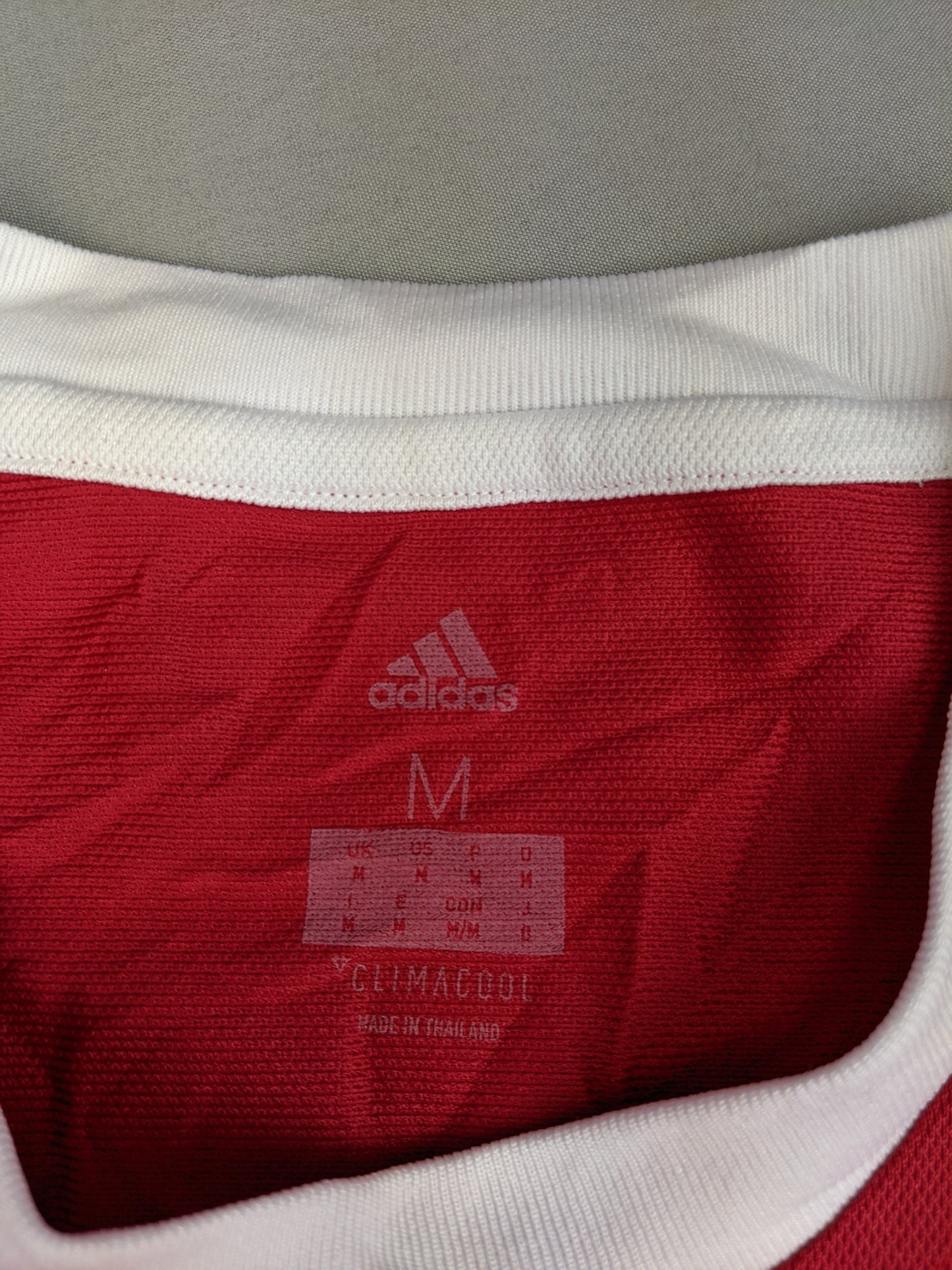 Close-up of the Adidas logo and size on Ajax jersey