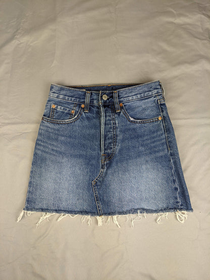 Front view of blue denim skirt with raw hem