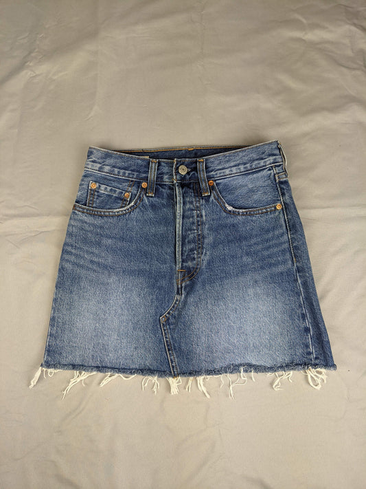 Front view of blue denim skirt with raw hem