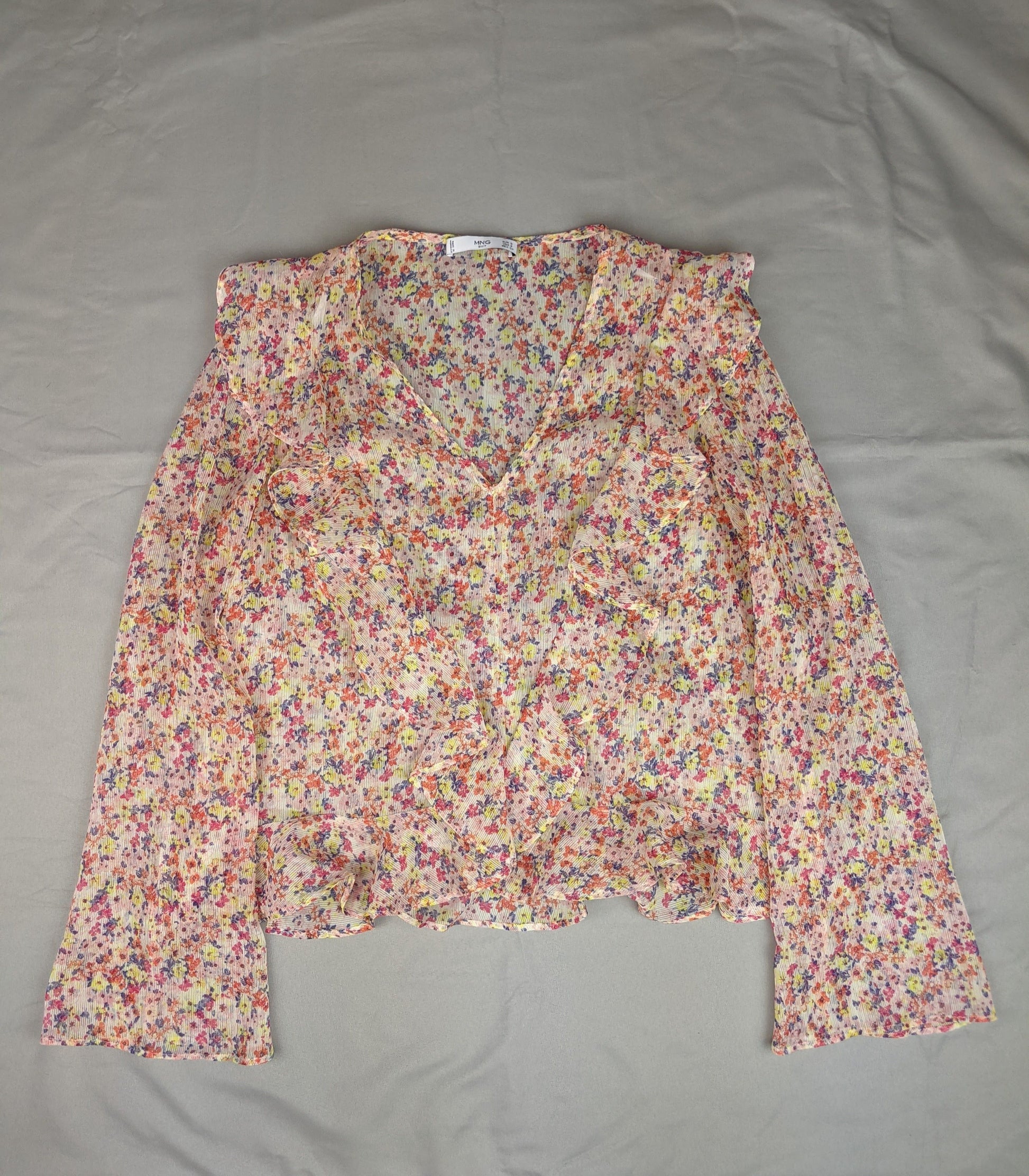 Floral ruffled blouse laid flat