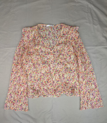 Floral ruffled blouse laid flat