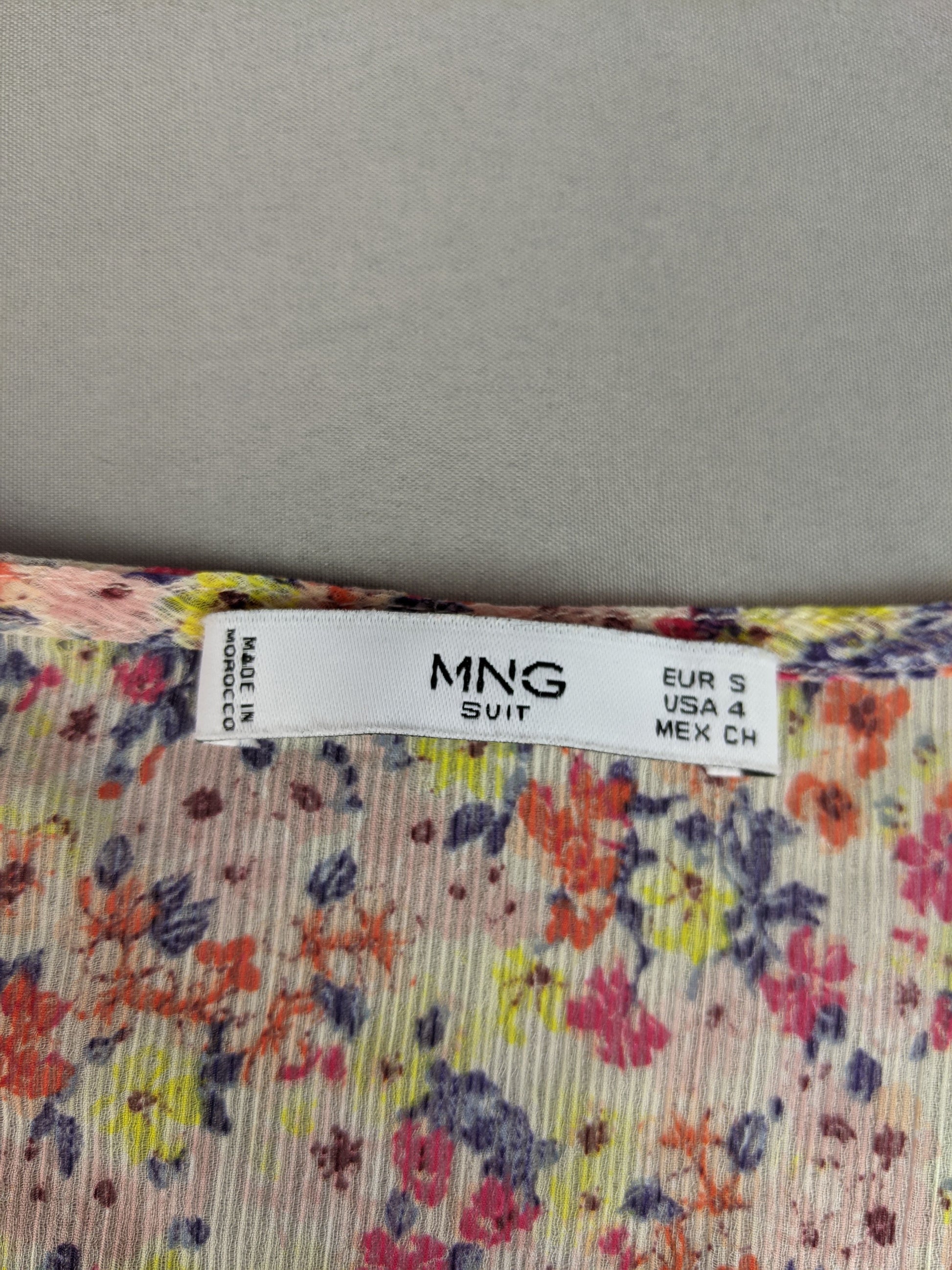 Close-up of MNG label on floral blouse
